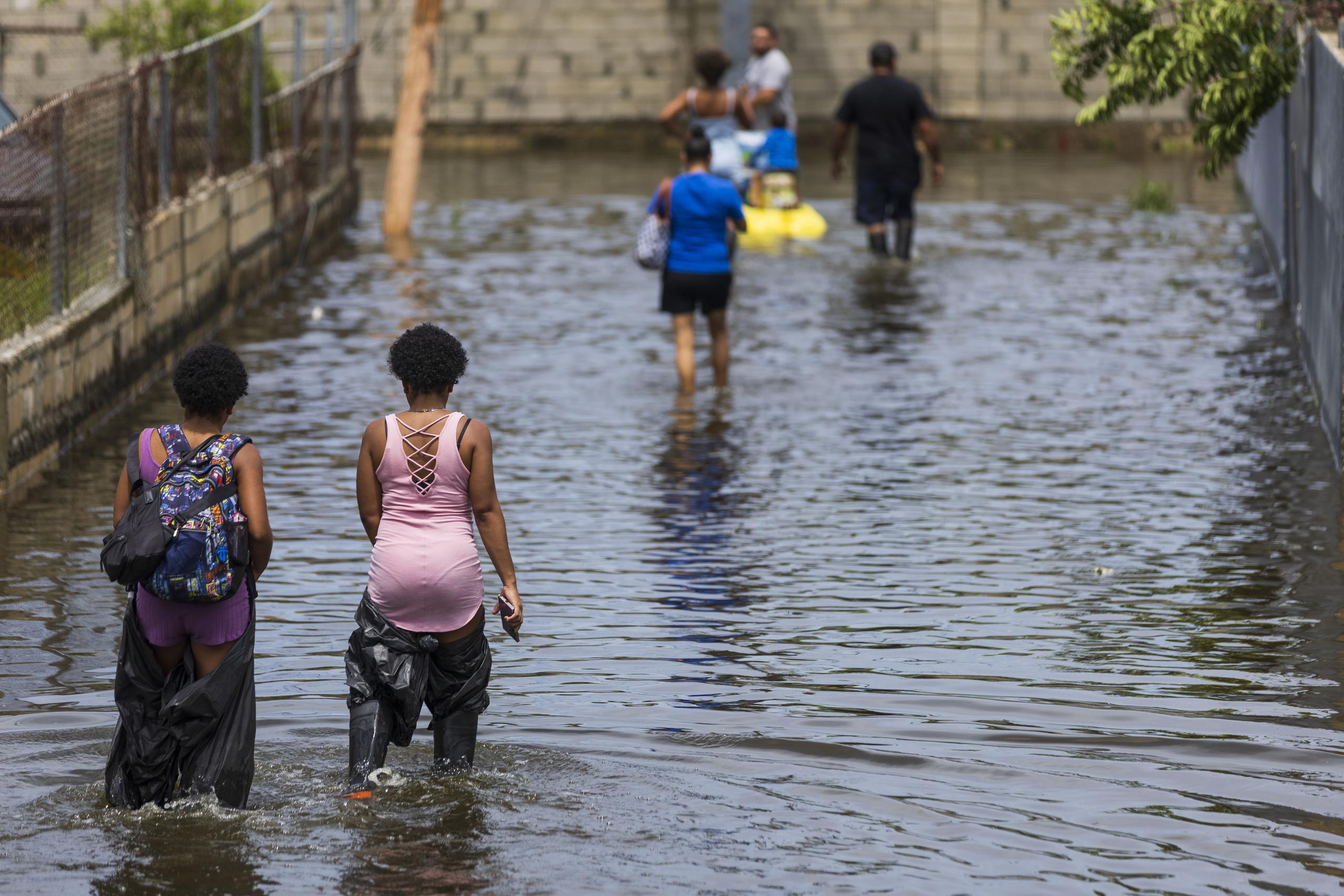 Residentes del barrio Villa Santos, en Loíza, caminan en medio de la inundación provocada por el huracán Fiona.