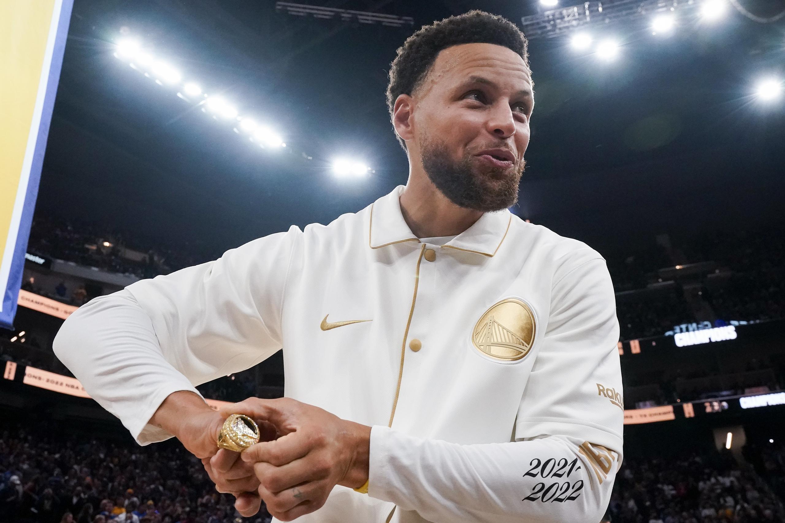Stephen Curry muestra su cuarto anillo de campeonato durante la ceremonia previo al primer partido de la temporada los Warriors contra los Lakers.