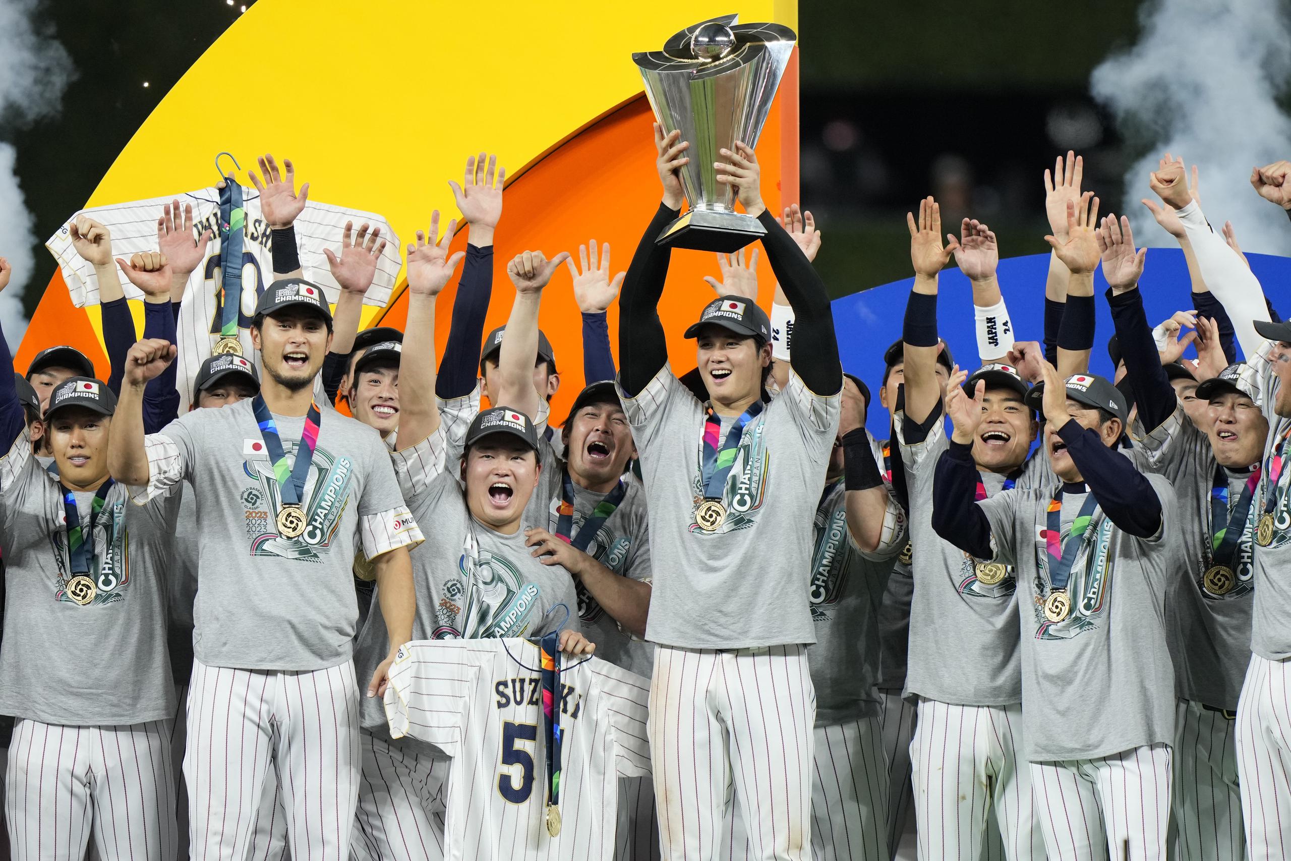 El lanzador Shohei Ohtani, Jugador Más Valioso de la final del Clásico Mundial de Béisbol, levanta el trofeo de campeón rodeado de sus compañeros del equipo de Japón.