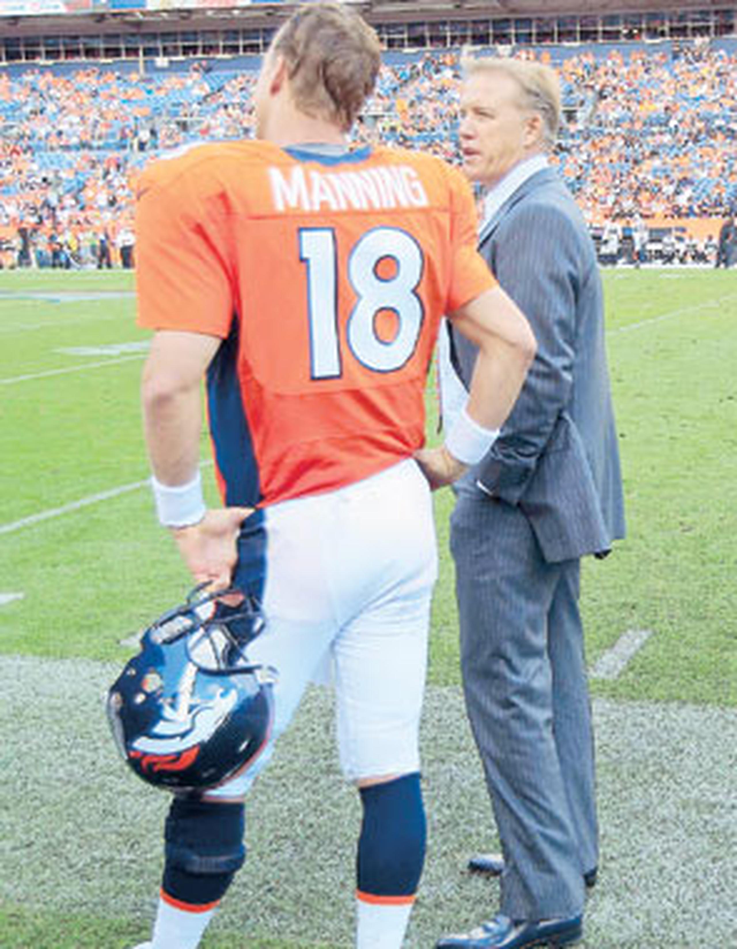 Peyton Manning y el ex quarterback John Elway conversan durante un juego de la temporada. (AP / David Zalubowski)