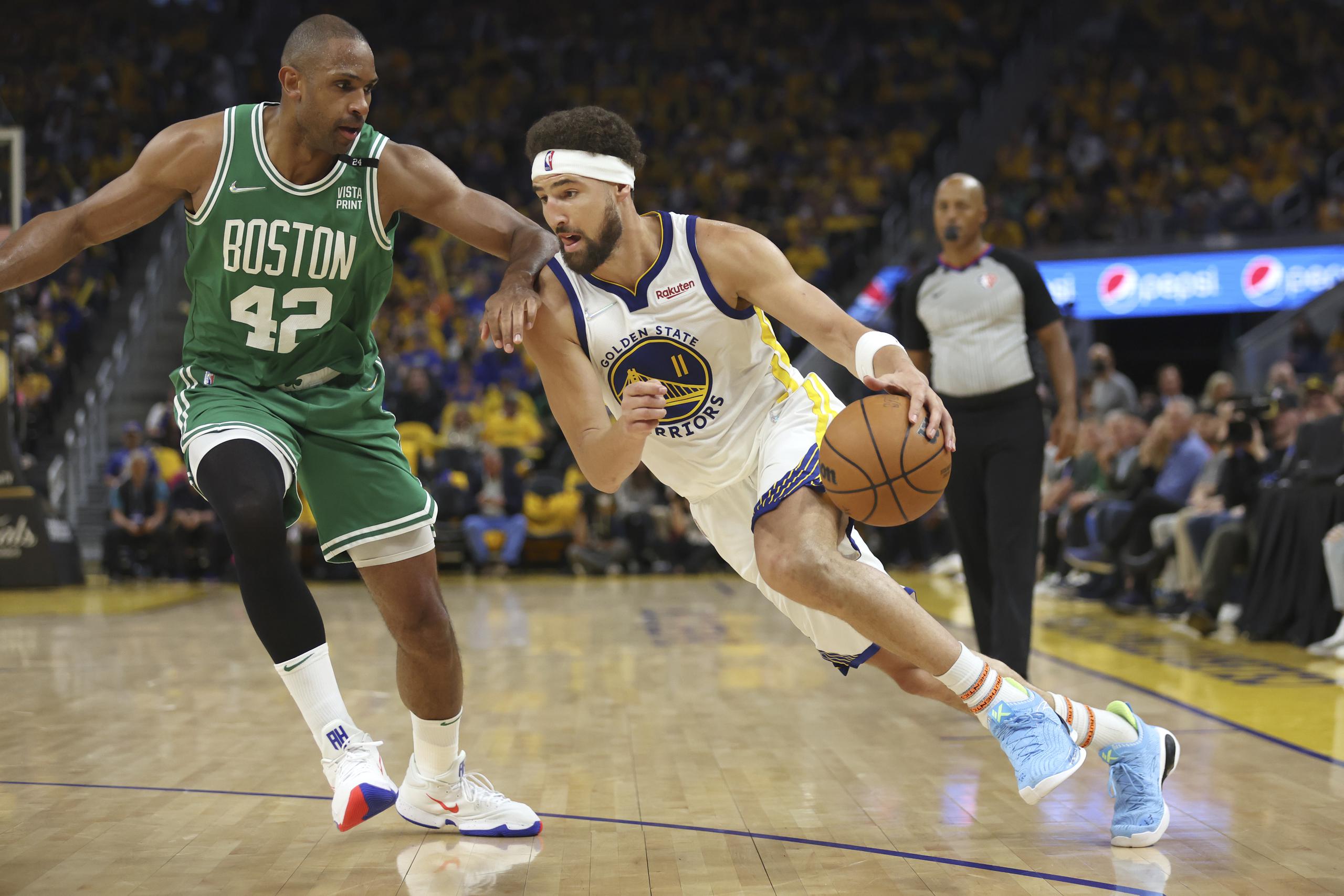 El dominicano Al Horford (42), de los Celtics de Boston, intenta obstruir el avance de Klay Thompson (11), de los Warriors de Golden State, en la segunda mitad del primer partido de las finales de la NBA disputado en San Francisco, el jueves 2 de junio de 2022. (AP foto/Jed Jacobsohn)
