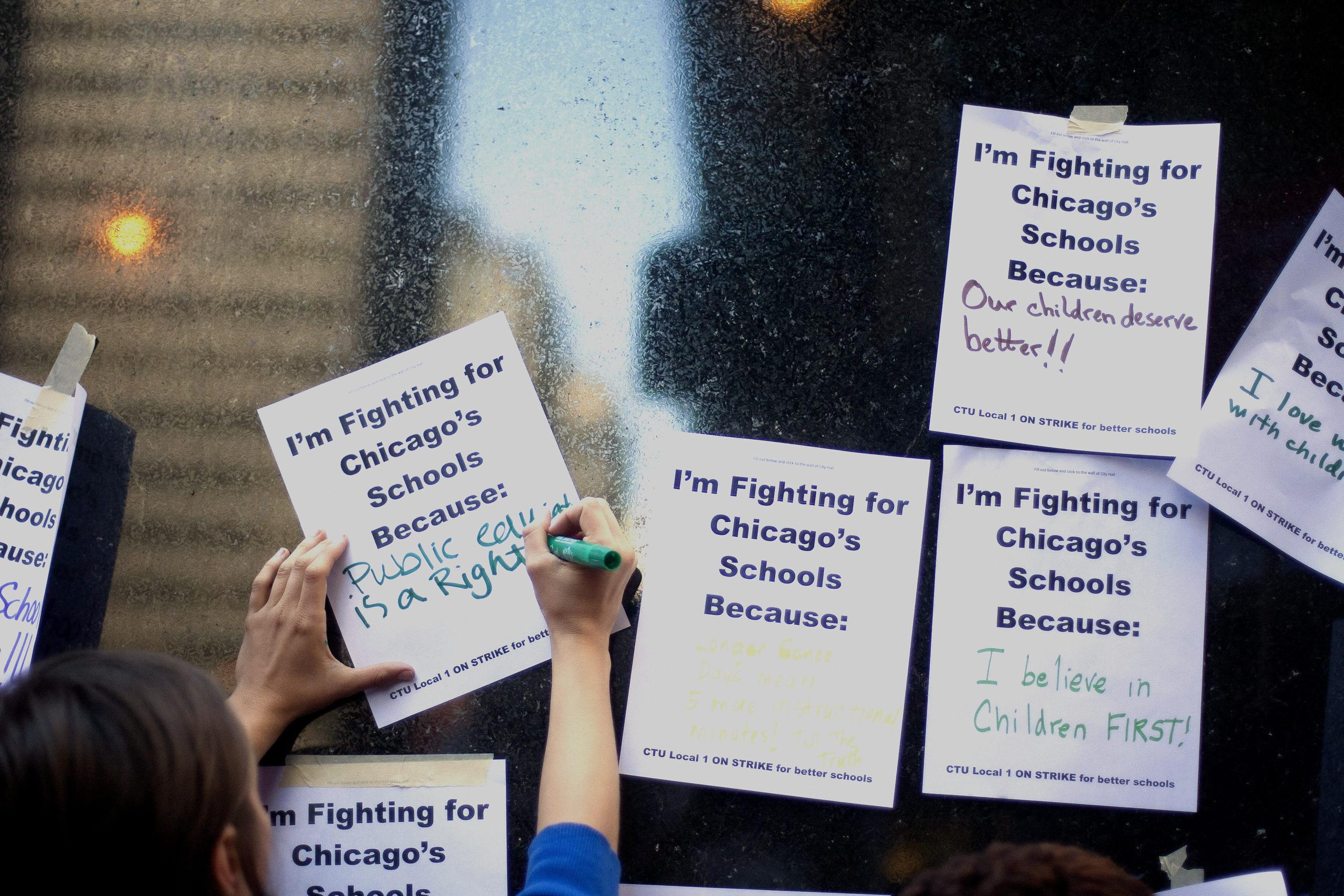 Una persona escribe su razón de apoyar a la huelga de maestros en la ciudad de Chicago.