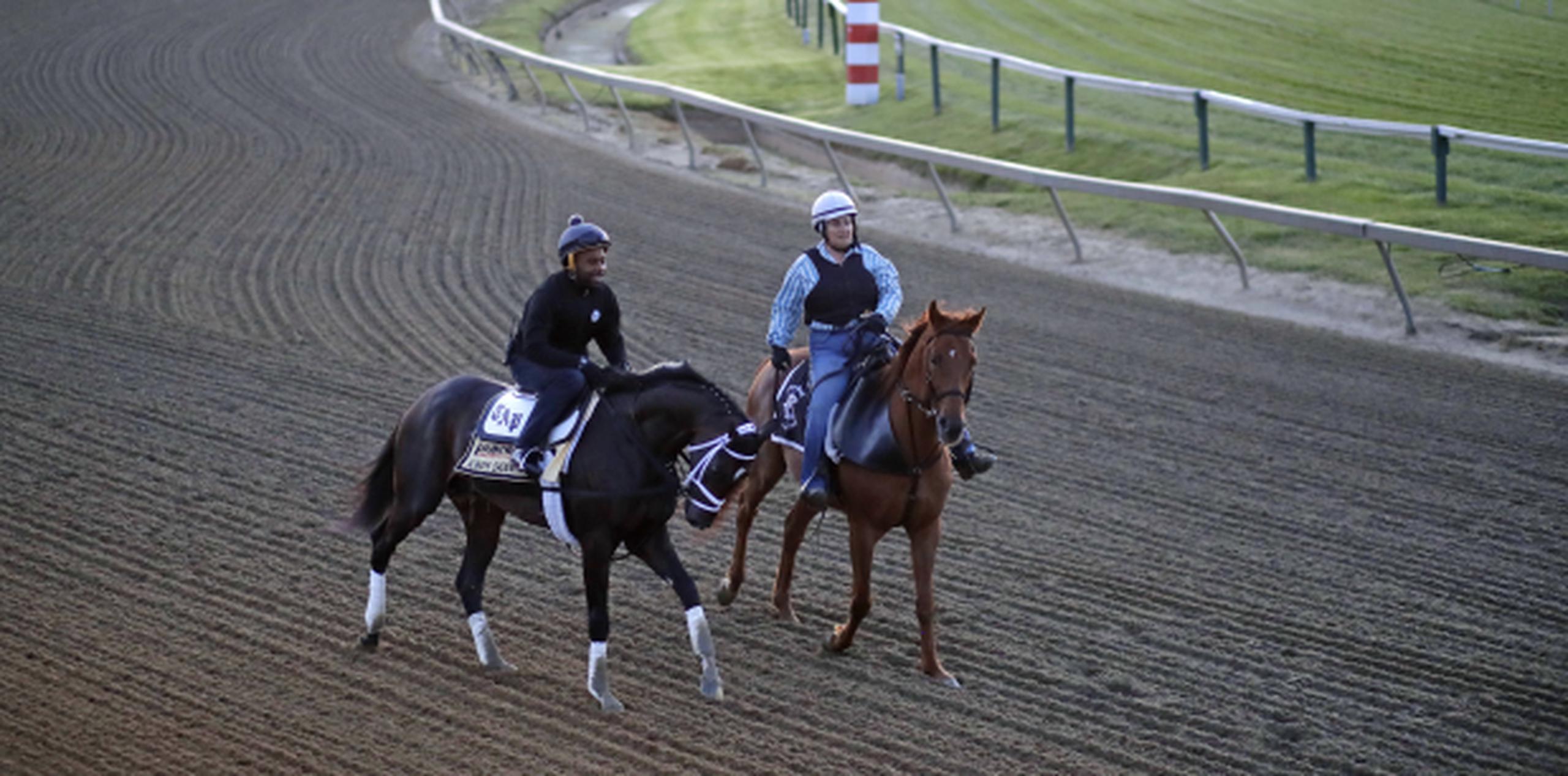 Always Dreaming, a la izquierda y montado por el jinete de entrenamiento Nick Bush, es guiado por un caballo guía a una sesión de entrenamiento ayer. (AP / Patrick Semansky)