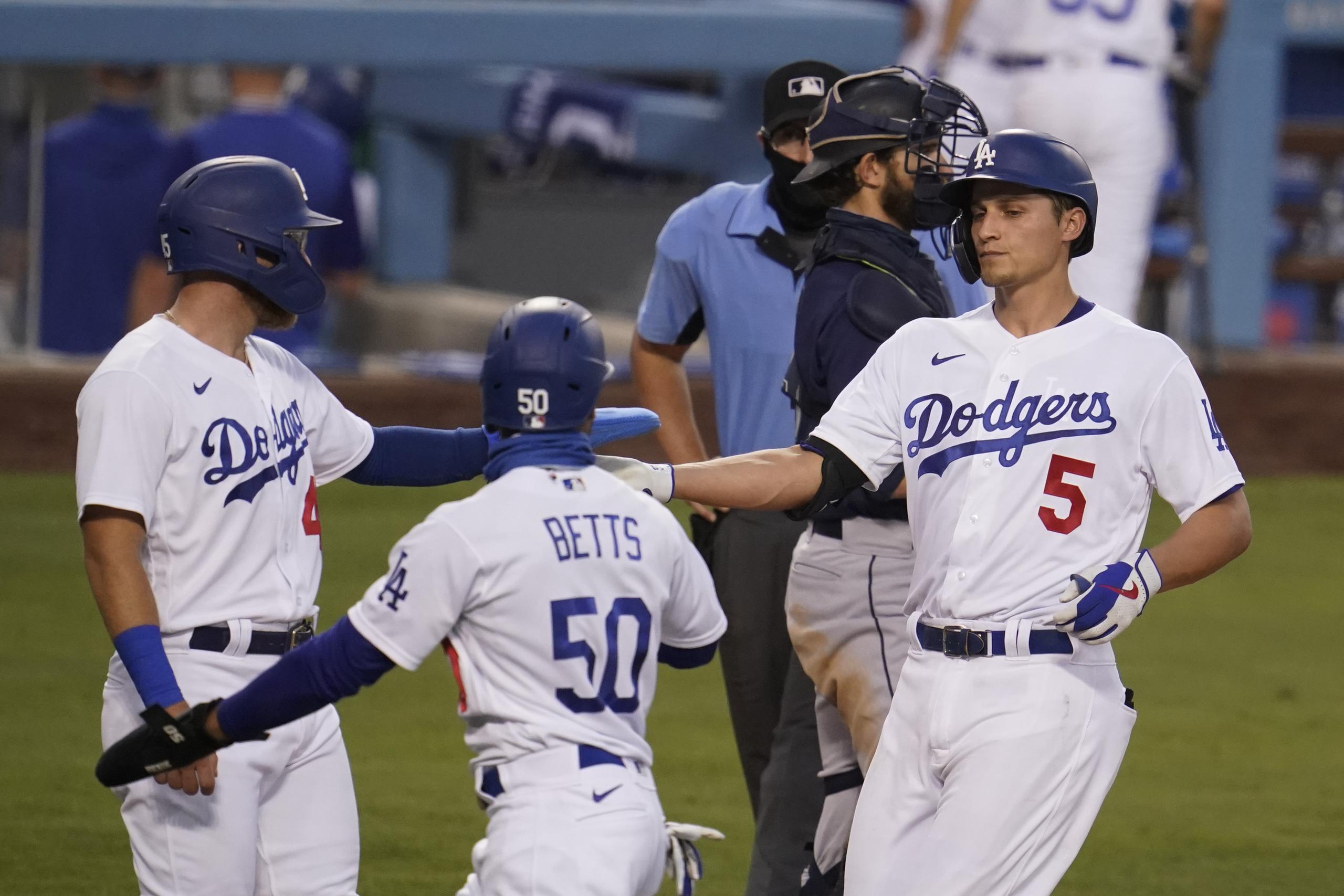 Corey Seager (5), de los Dodgers de Los Ángeles, celebra su cuadrangular de tres carreras con Mookie Betts (50) y Matt Beaty en el segundo inning del juego de la MLB que enfrentó a su equipo con los Marineros de Seattle.