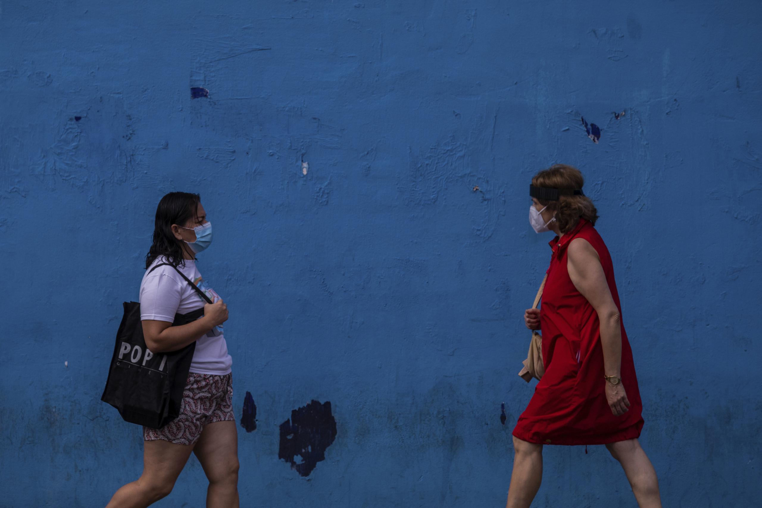 Dos mujeres con mascarillas protectoras contra el coronavirus caminan por el barrio de Vallecas, Madrid.