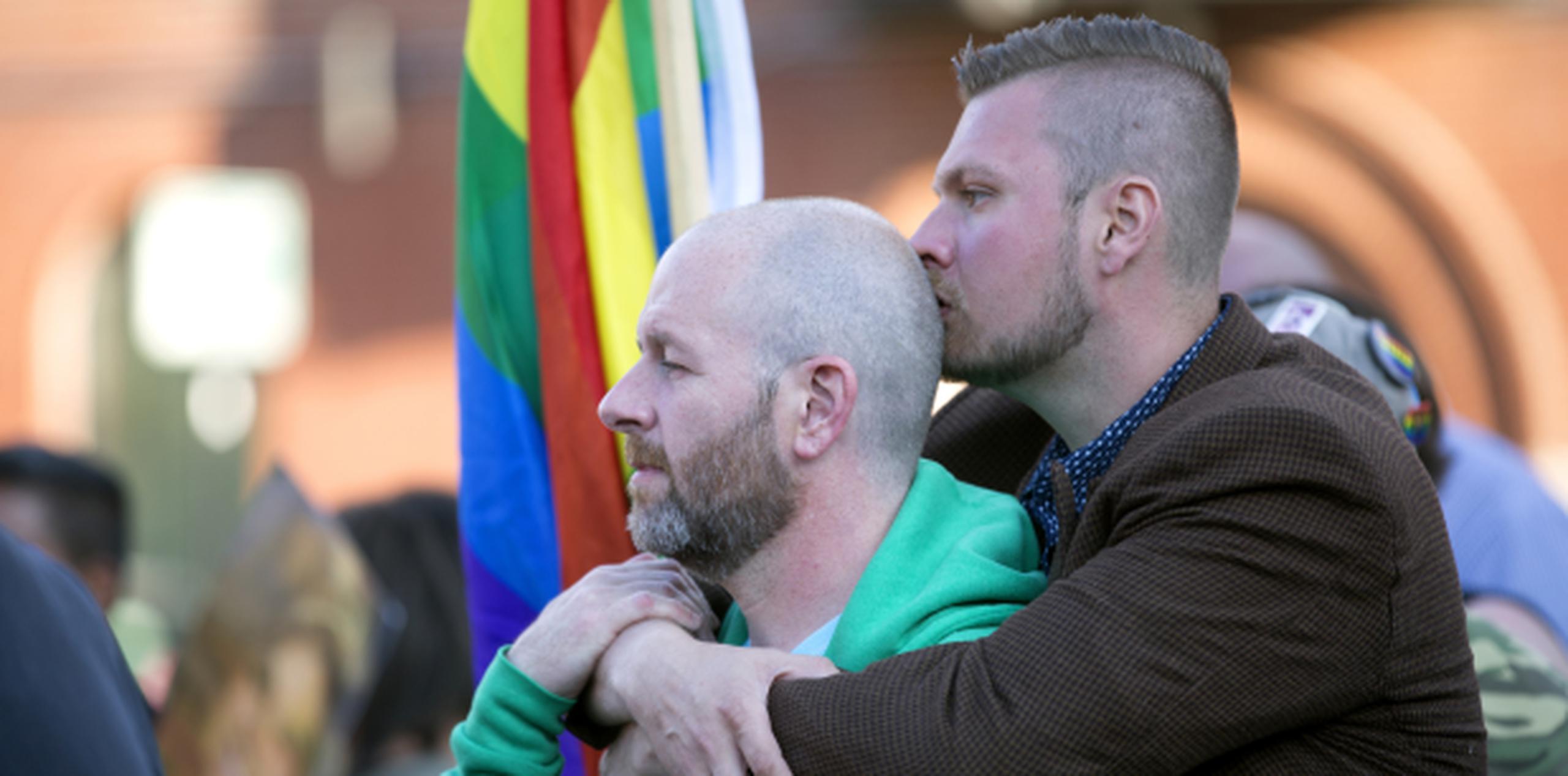 Joshua Oaks (derecha), pone sus brazos alrededor de su compañero de Mark Flanagan durante una vigilia por las víctimas del tiroteo club nocturno de Orlando, en Boystown, Chicago. (Erin Hooley/Chicago Tribune vía AP)