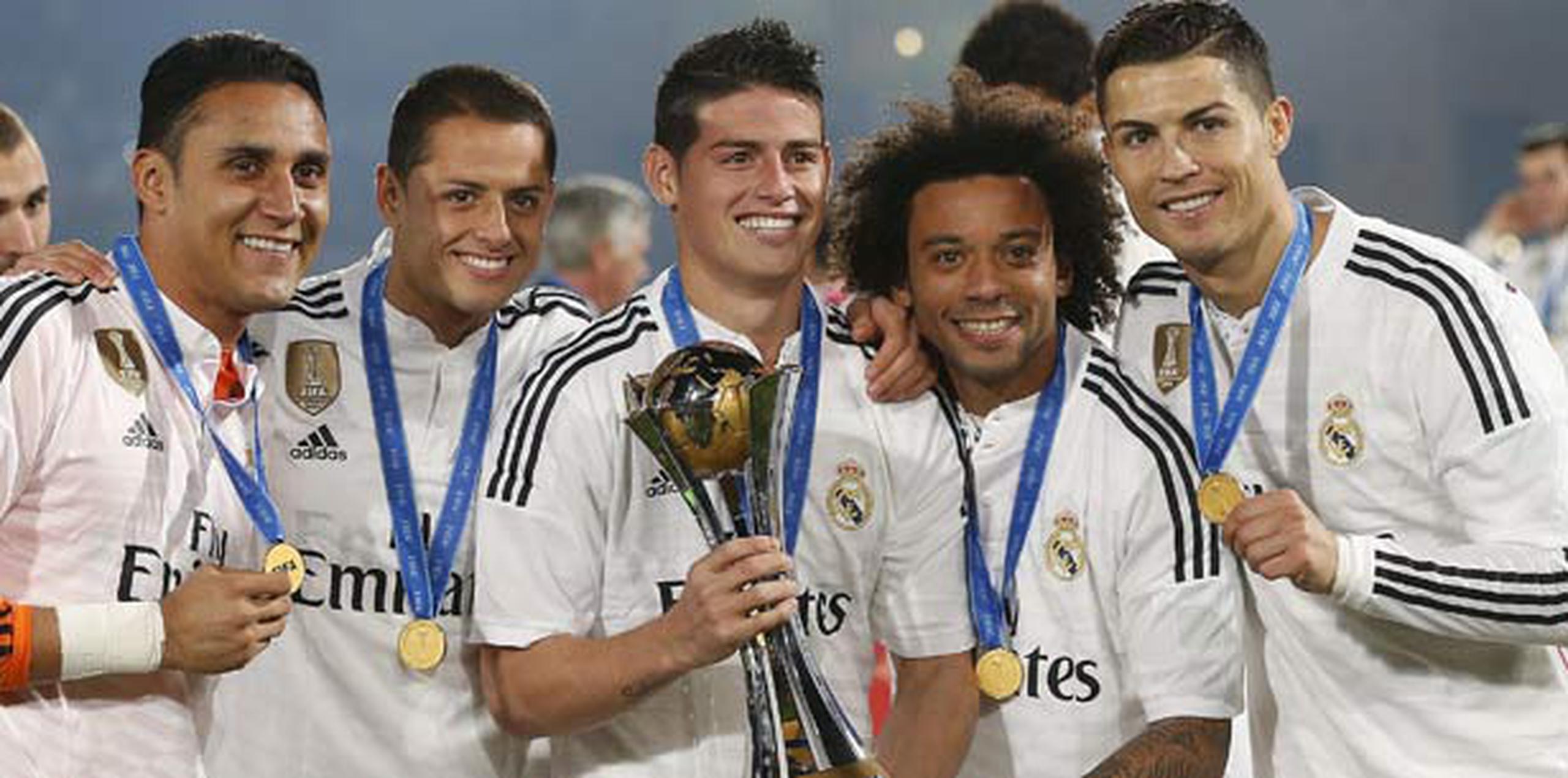 Jugadores del Real Madrid, encabezados por James Rodríguez (con trofeo en mano) y Cristiano Ronaldo, a la extrema derecha celebran el reciente título del Mundial de Clubes que ganó el monarca europeo. (EFE / Chema Moya)