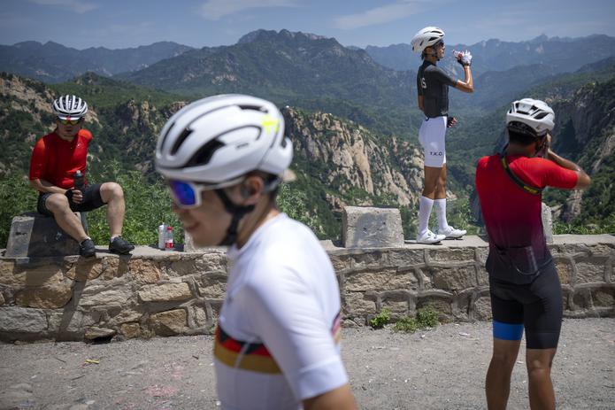 Cuatro ciclistas se toman un descanso durante un recorrido por una zona montañosa de las afueras de Beijing el 13 de julio del 2022. (AP Photo/Mark Schiefelbein)