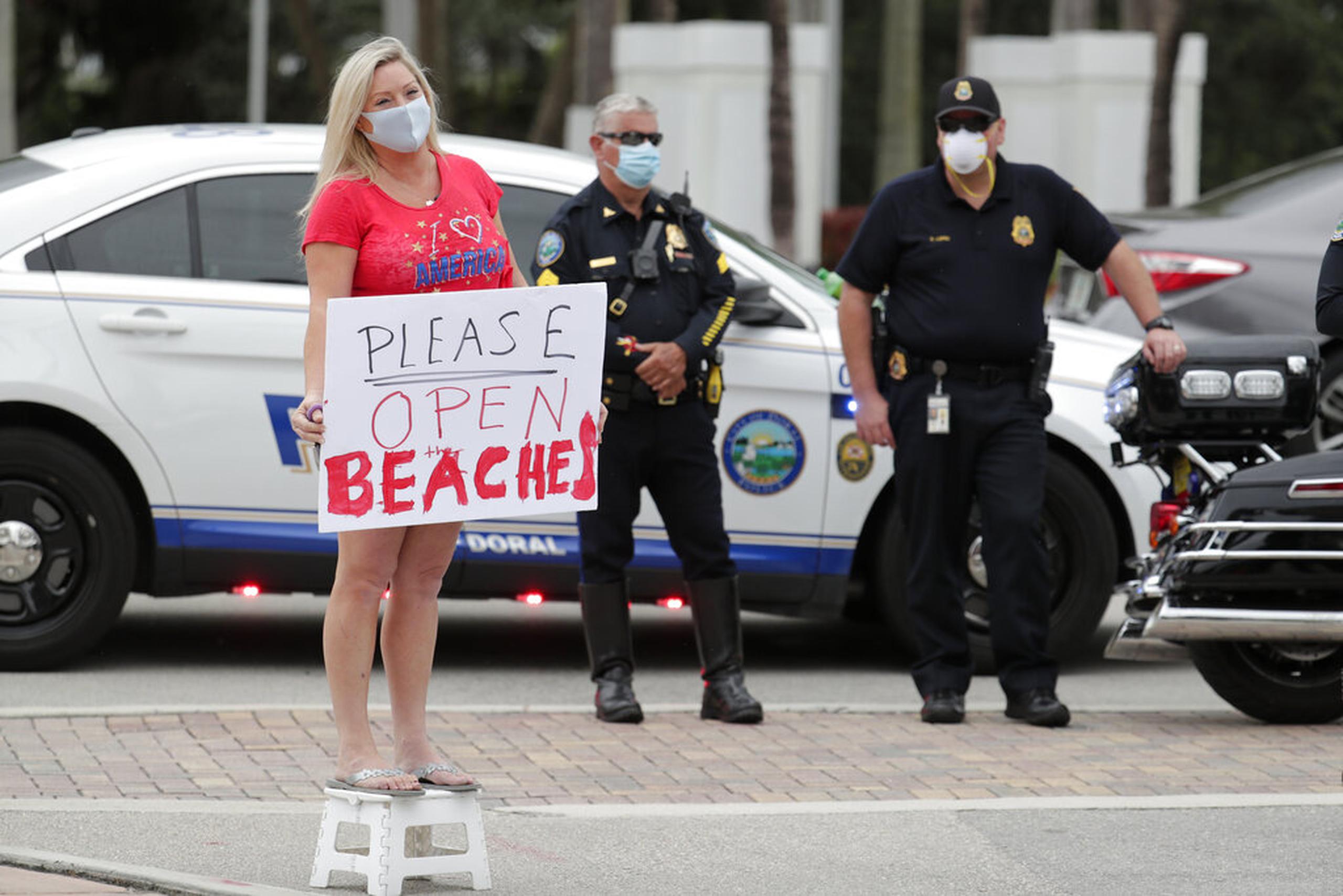 Una mujer protestó ayer, jueves, por la reapertura de las playas en la ciudad de Doral, en Florida.