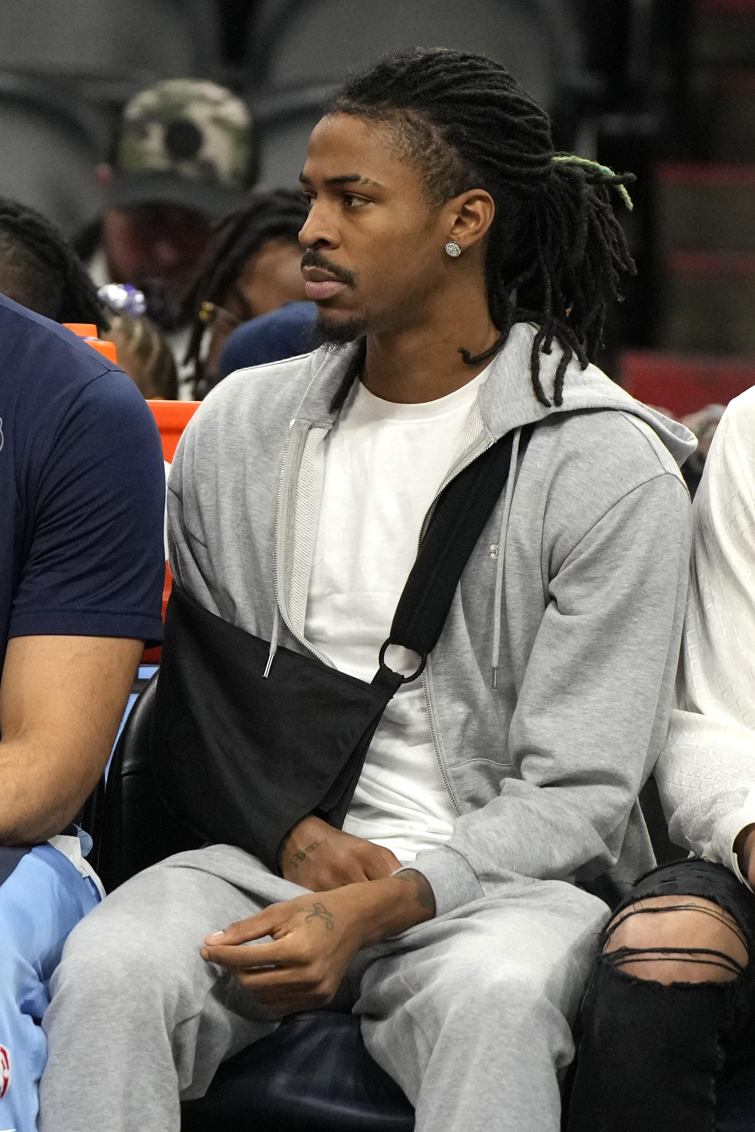 El base de los Grizzlies de Memphis, Ja Morant, aparece aquí con el brazo en un cabestrillo sentado en la banca en el encuentro ante los Suns de Phoenix el domingo 7 de enero del 2024.