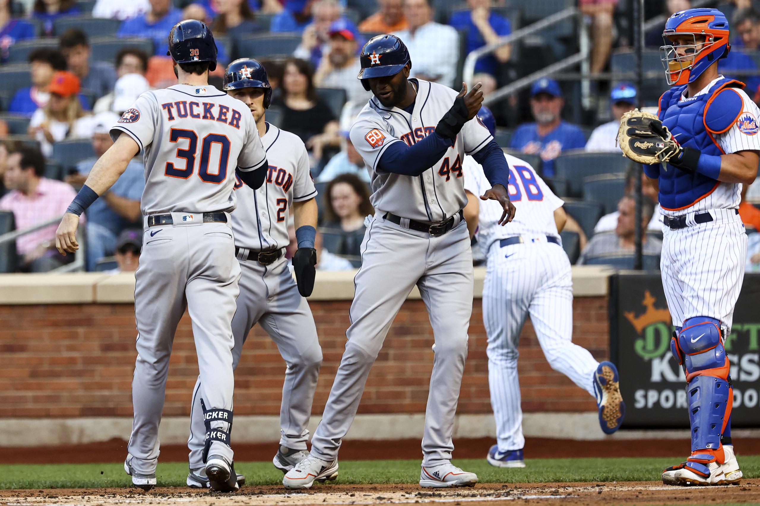 Al centro, Yordan Álvarez felicita a su compañero de los Astros de Houston, Kyle Tucker, luego de que este sacudiera un jonrón de tres carreras el martes ante los Mets de Nueva York.