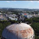 Tito Kayak iza bandera en la torre de agua de Oso Blanco para exigir cierre del Zoológico de Mayagüez