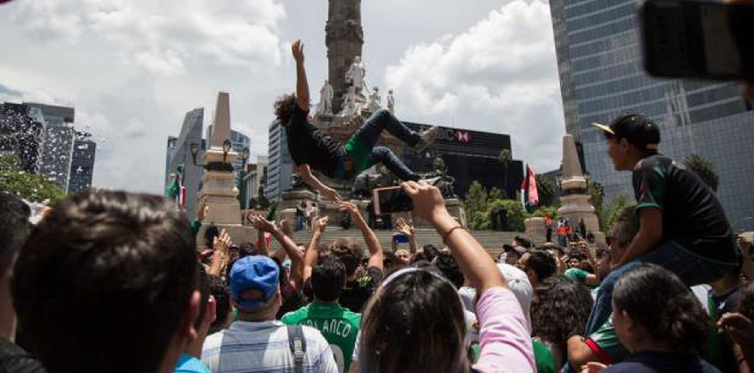 Decenas de mexicanos salieron a celebrar el triunfo en los alrededores del Ángel de la Independencia. (AP)