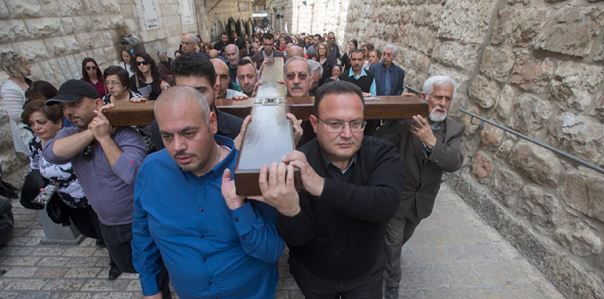 Peregrinos católicos cargan con la cruz durante un a procesión de Viernes Santo en la Vía Dolorosa dentro de la Ciudad Vieja de Jerusalén. (EFE/Atef Safadi)
