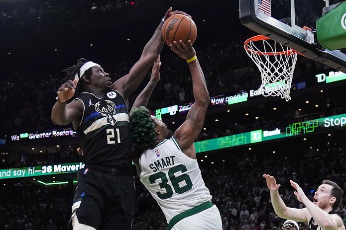 El defensa de los Bucks de Milwaukee, Jrue Holiday (21), le bloquea un tiro a Marcus Smart, de los Celtics de Boston, durante los segundos finales del partido del miércoles en Boston.