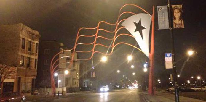 El Paseo Boricua es demarcado por dos banderas metálicas gigantes de Puerto Rico de 18 metros de altura que se inauguraron hace 20 años . (Facebook/Jayson Vázquez)