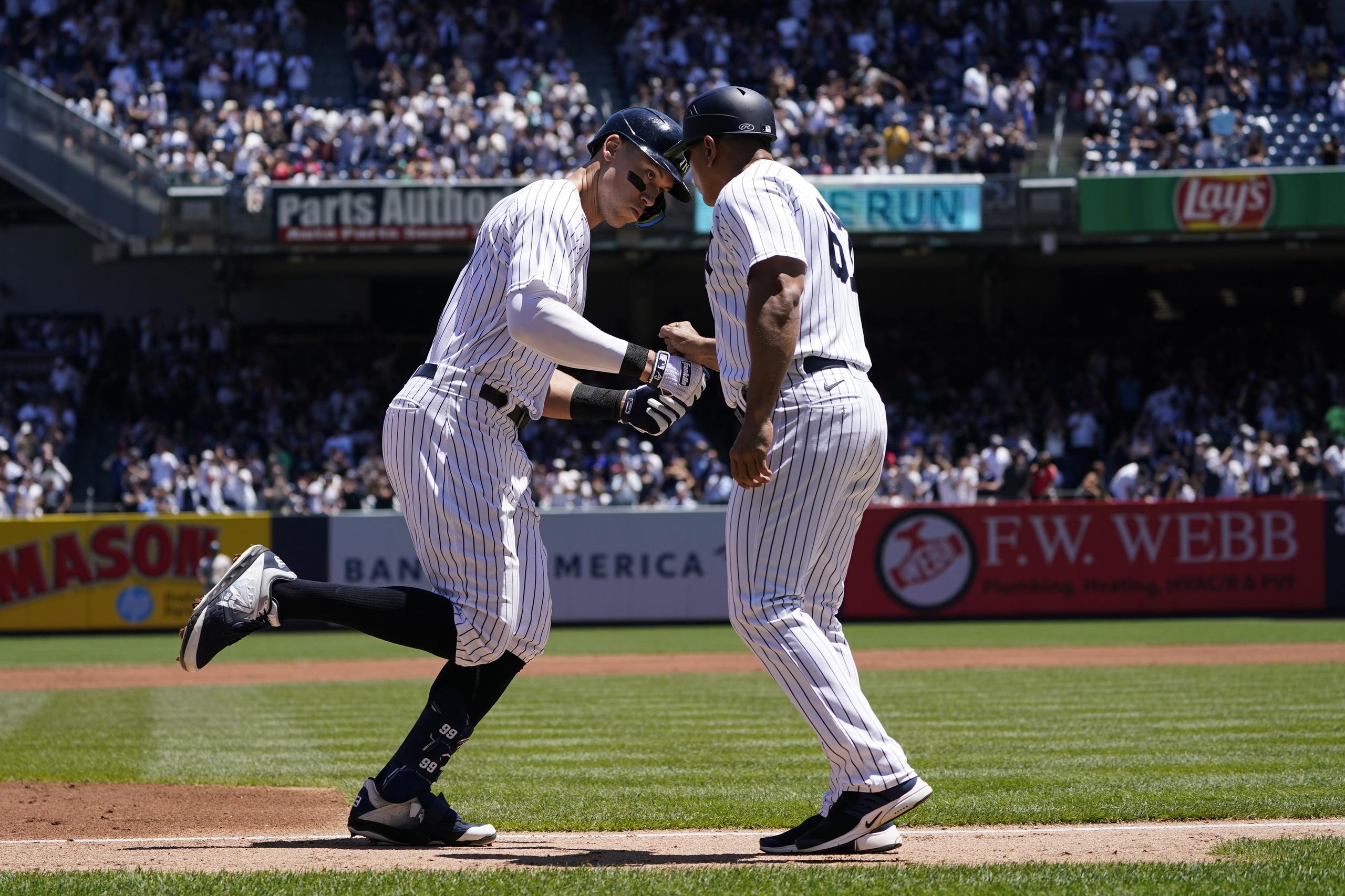 Aaron Judge de los Yankees de Nueva York celebra con el coach de tercera base Luis Rojas tras conectar un jonrón en la primera entrada ante los Atléticos de Oakland el miércoles 29 de junio del 2022. (AP Foto/Seth Wenig)