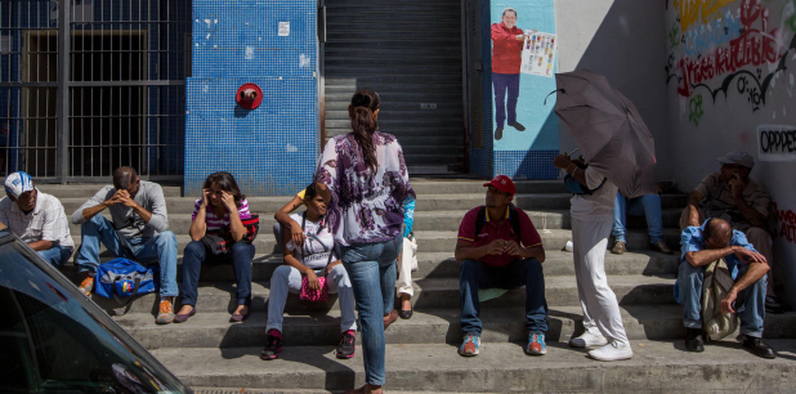 Un grupo de personas hace fila en las inmediaciones del Banco Central de Venezuela. (Agencia EFE)