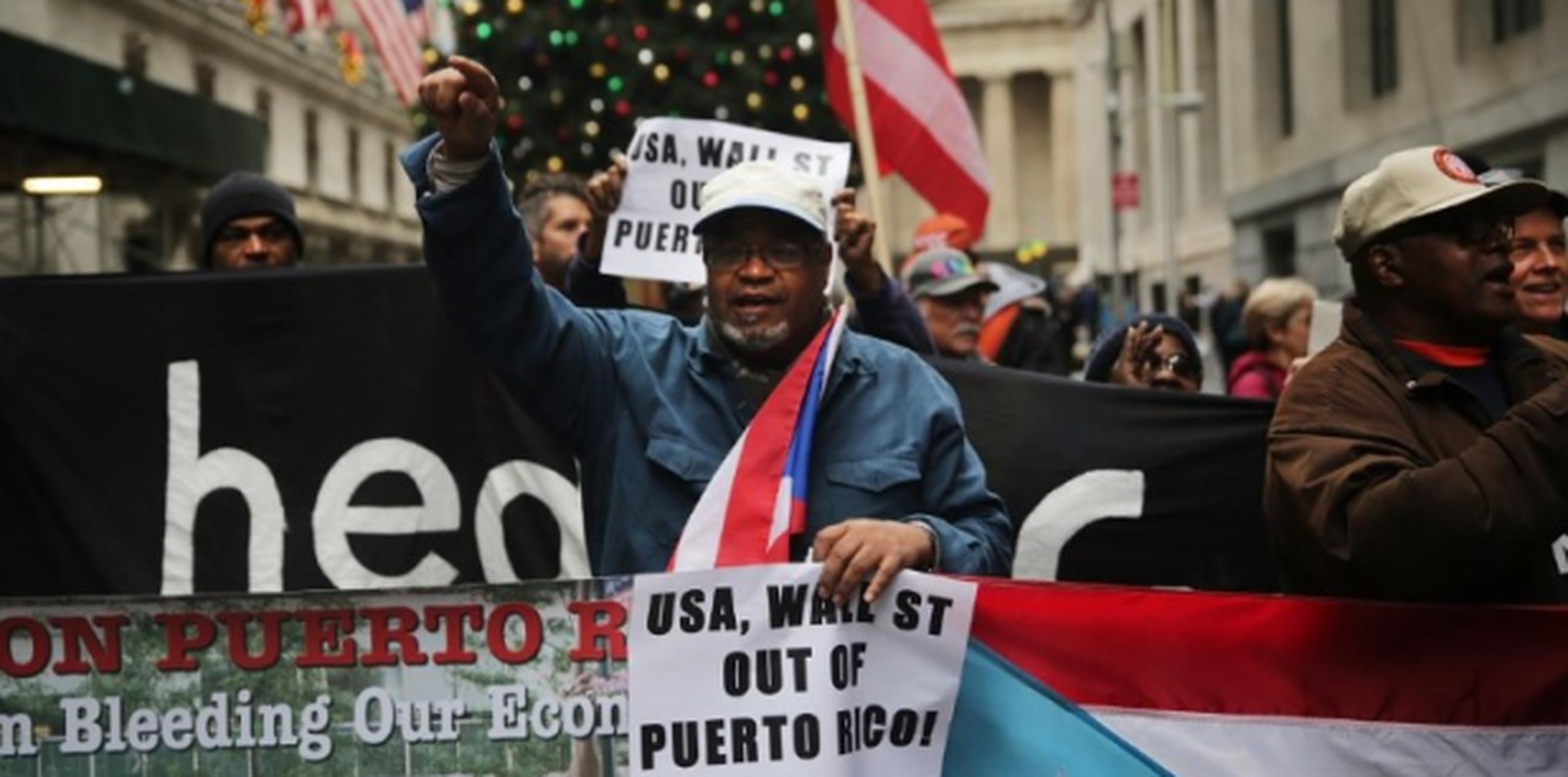Según David Galarza, portavoz del grupo que se congregó como parte del Día Nacional de Acción por Puerto Rico, declarar al país en bancarrota, como gestiona el Gobierno de la isla ante el Congreso federal, es sólo "poner un vendaje, algo temporero" para cubrir "el real problema". (AFP)