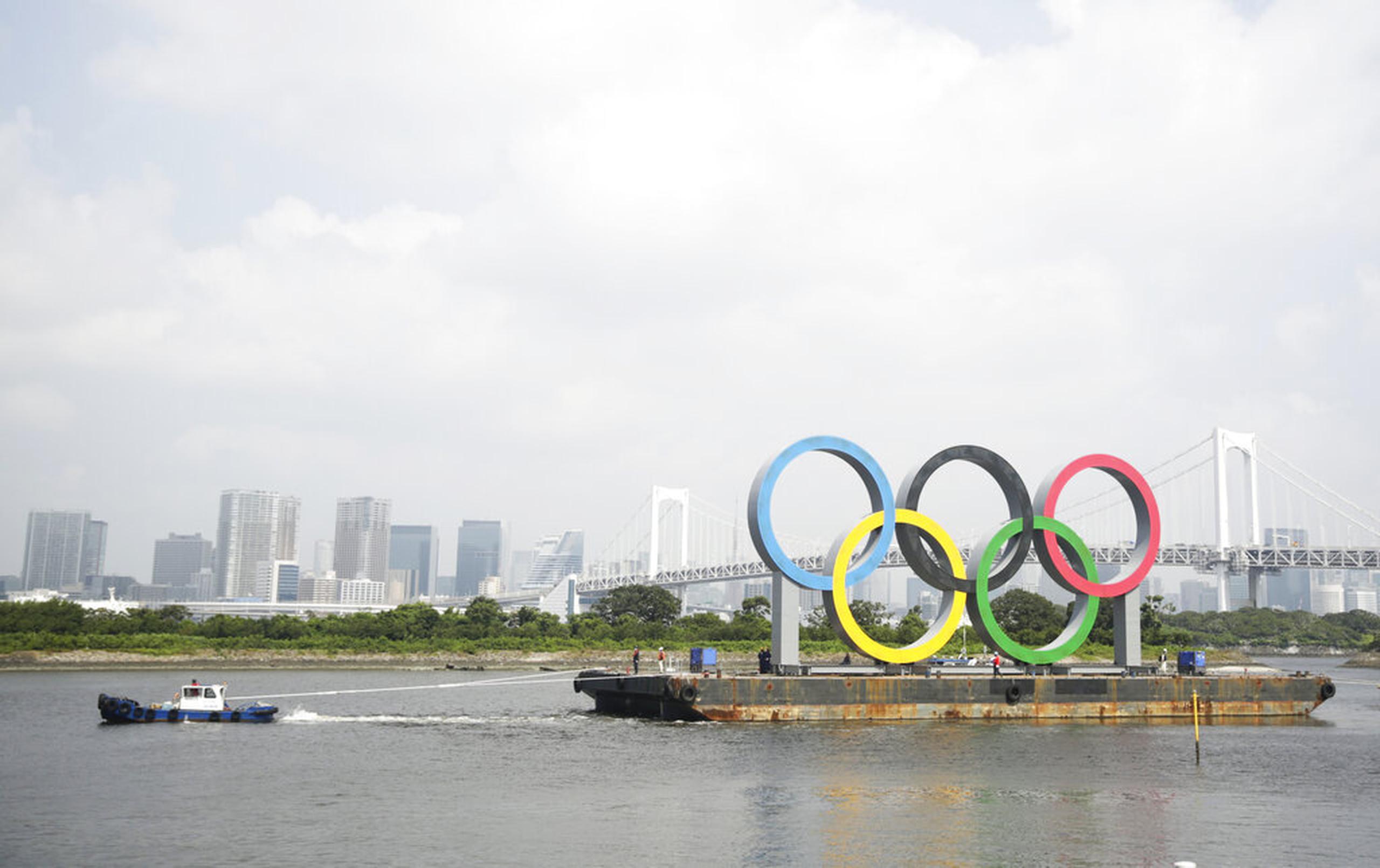 Una remolcadora trasladó la barcaza en la que se instalaron los anillos olímpicos en Tokio.