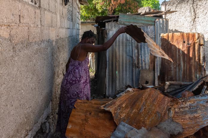 Una mujer busca entre los destrozos de su casa pertenencias que pueda recuperar, el 25 de mayo de 2022 en la comuna de Tabarre, distrito de Puerto Príncipe (Haití). EFE / Johnson Sabin
