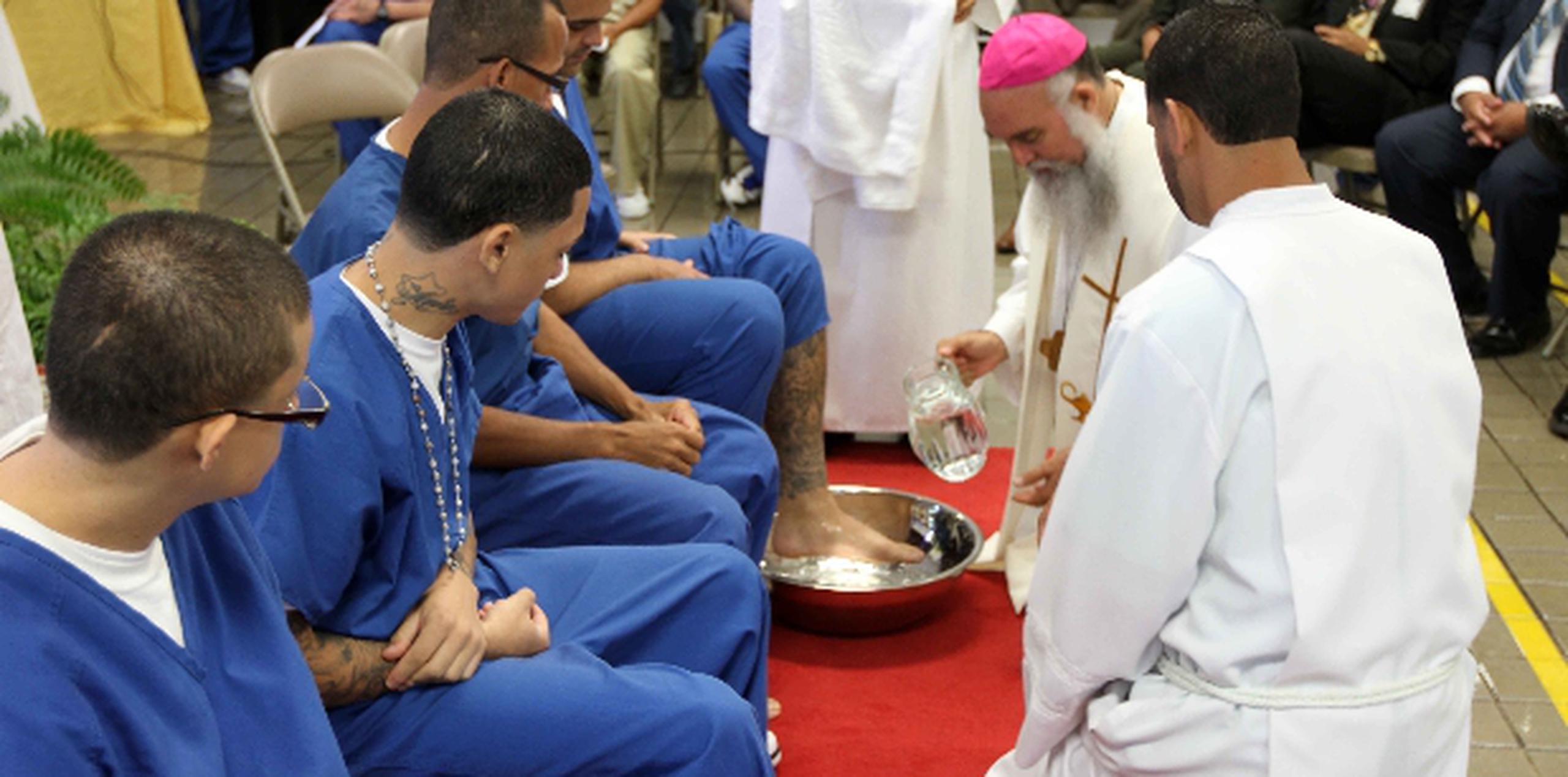 El obispo Rubén Antonio González lava los pies de uno de 12 confinados en el Complejo Correccional de Guayama. Suministrada