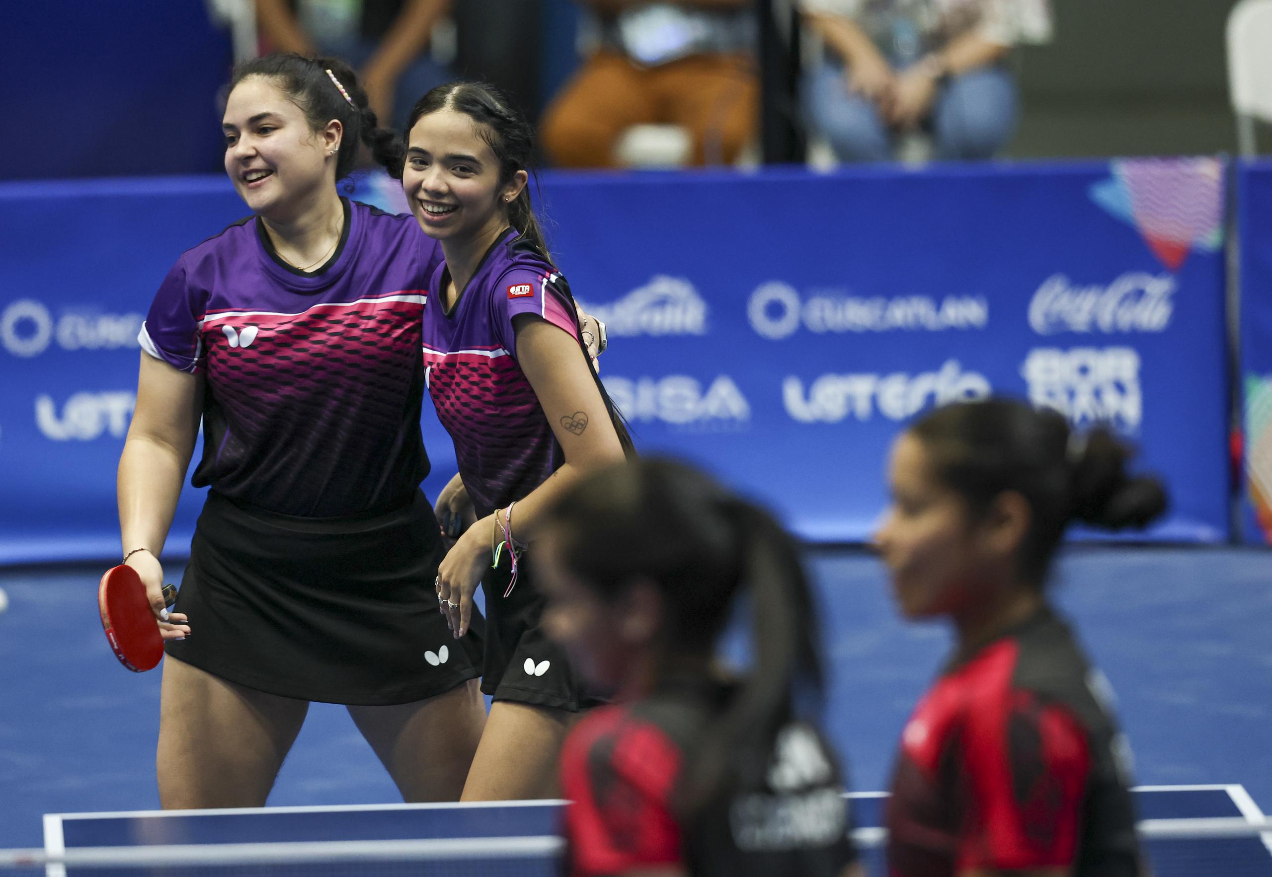 Brianna Burgos, a la izquierda, sonríe junto a Melanie Díaz al sacar uno de los puntos del partido doble ante Venezuela.
