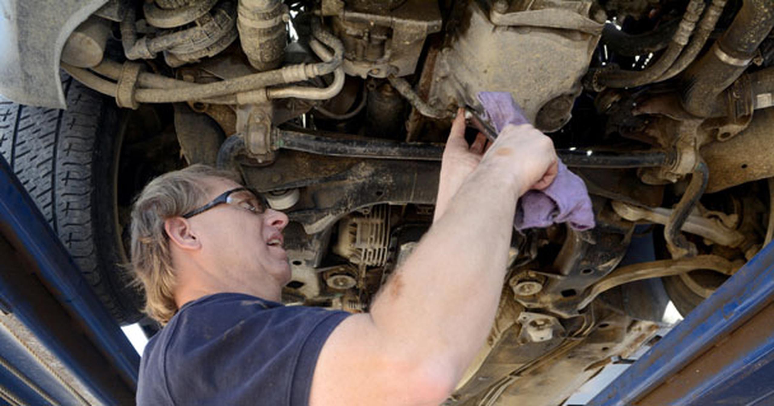 Alderson usa sus manos para sentir las diferentes piezas del auto. (Foto AP/The Albuquerque Journal)