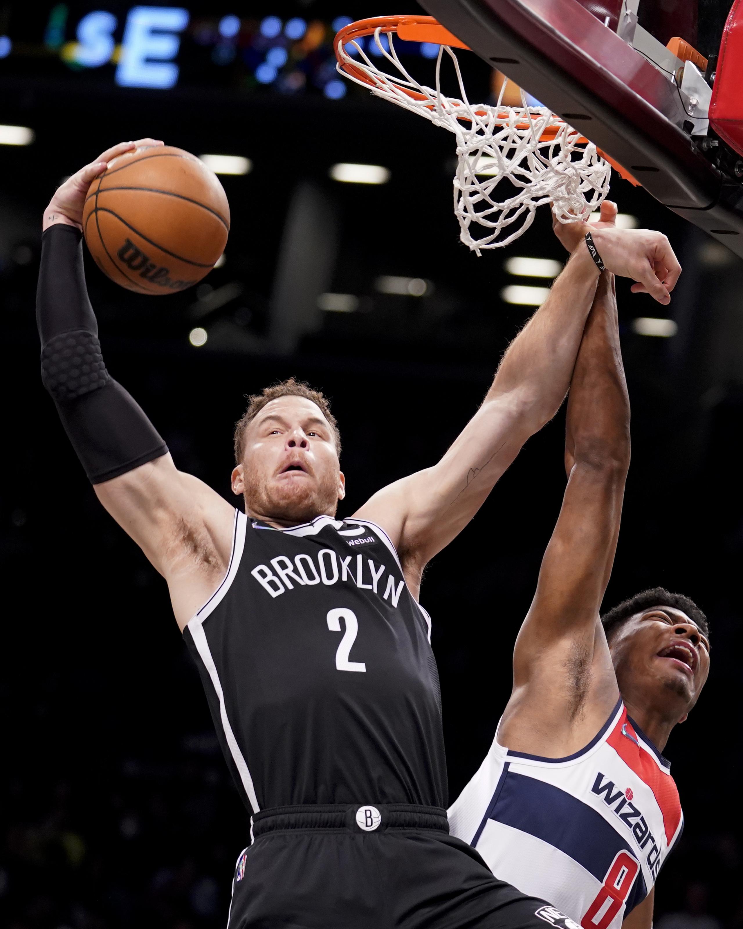 En foto del 17 de febrero del 2022, Blake Griffin de los Nets de Brooklyn toma un rebote superando al alero de los Wizards de Washington Rui Hachimura. (AP Foto/John Minchillo)