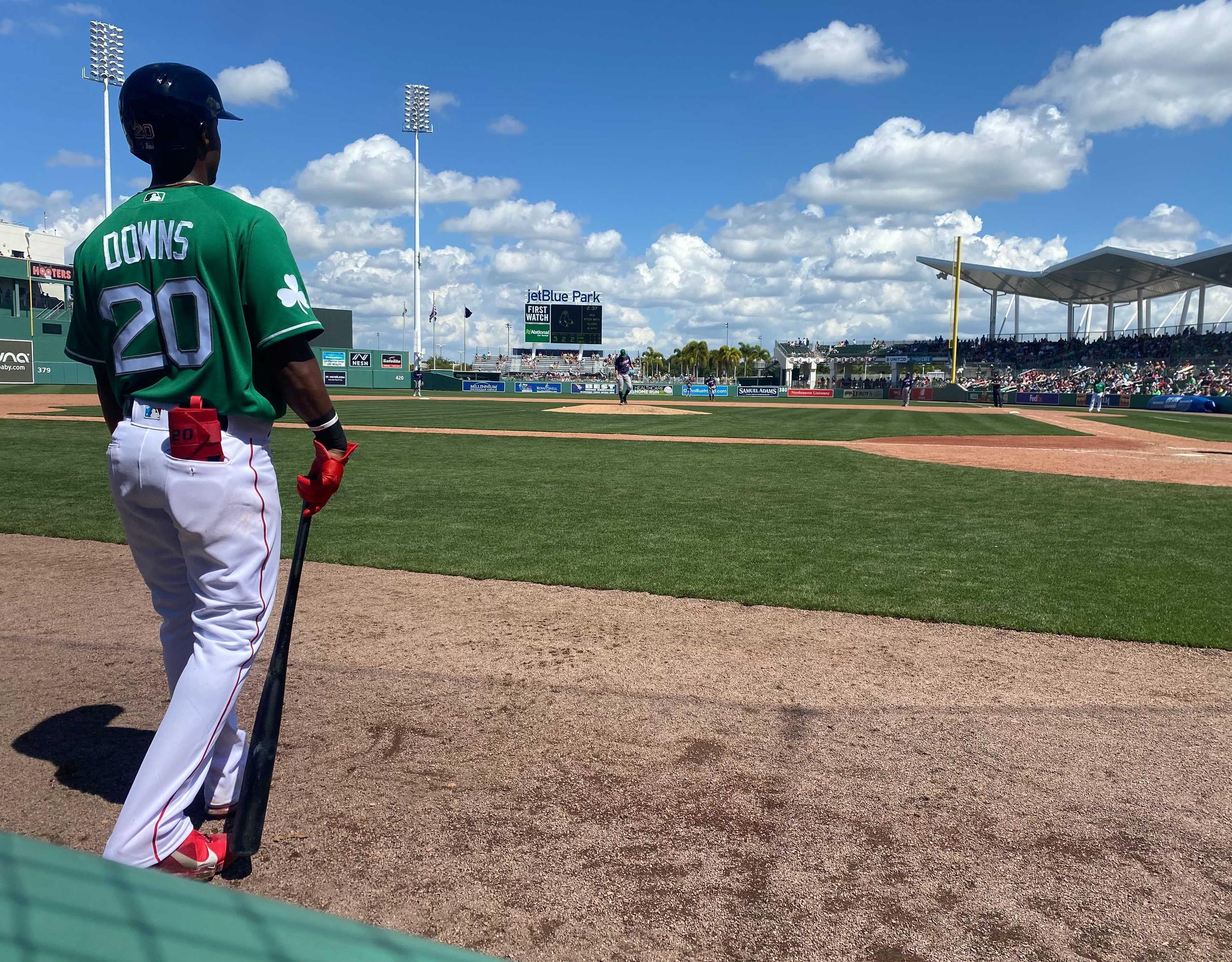 Jeter Downs de los Red Sox espera un turno a la caja de bateo. Llevó camisa verde por las festividades del Día de San Patricio.