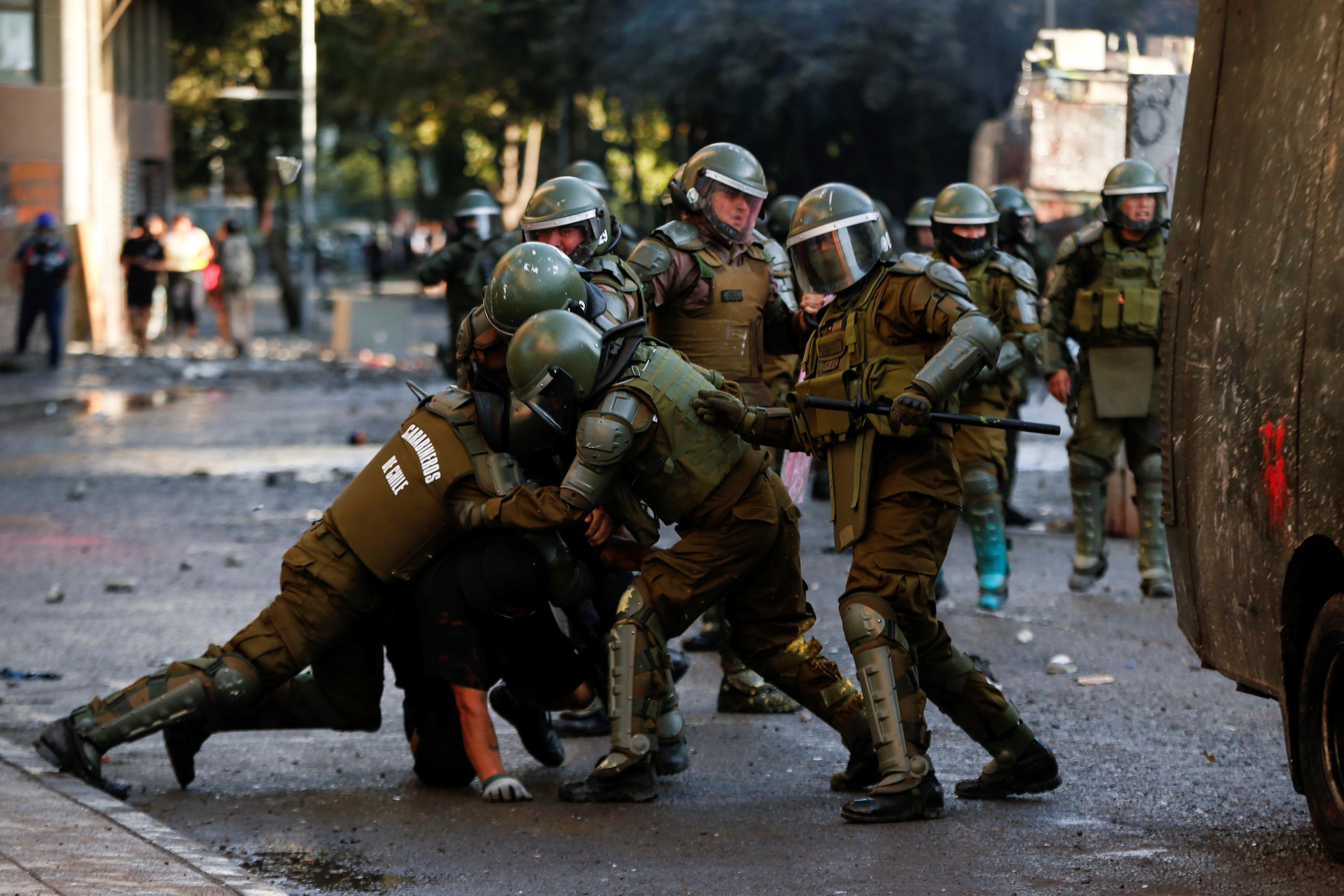 Integrantes de la Policía de Chile detienen a un manifestante durante una protesta en la céntrica Plaza Italia en Santiago