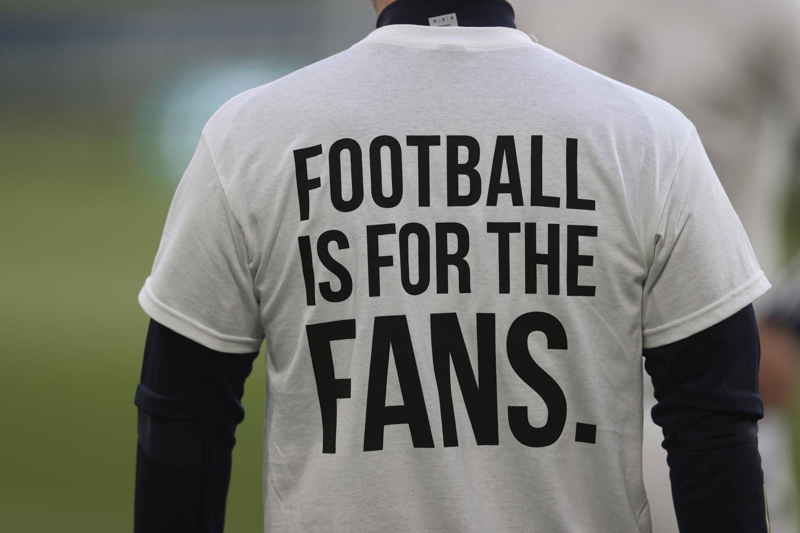Un jugador del Leeds United porta una camiseta con el mensaje "El fútbol es para los aficionados" previo a un partido de la Liga Premier inglesa contra el Liverpool en Leeds, Inglaterra.