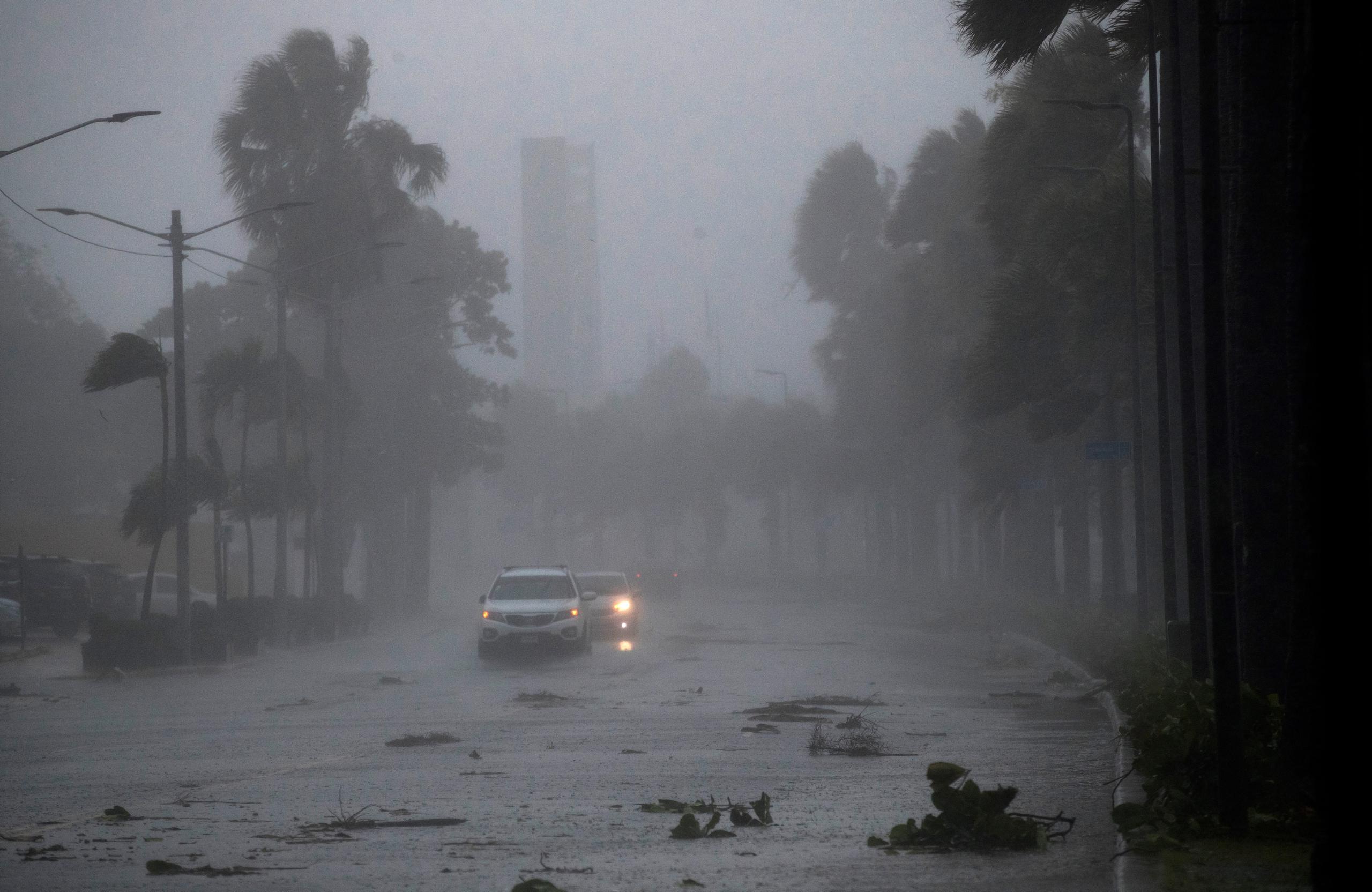 Vehículos circulan bajo la intensa lluvia durante el paso de la tormenta tropical Fred, el 11 de agosto de 2021 en Santo Domingo, República Dominicana.