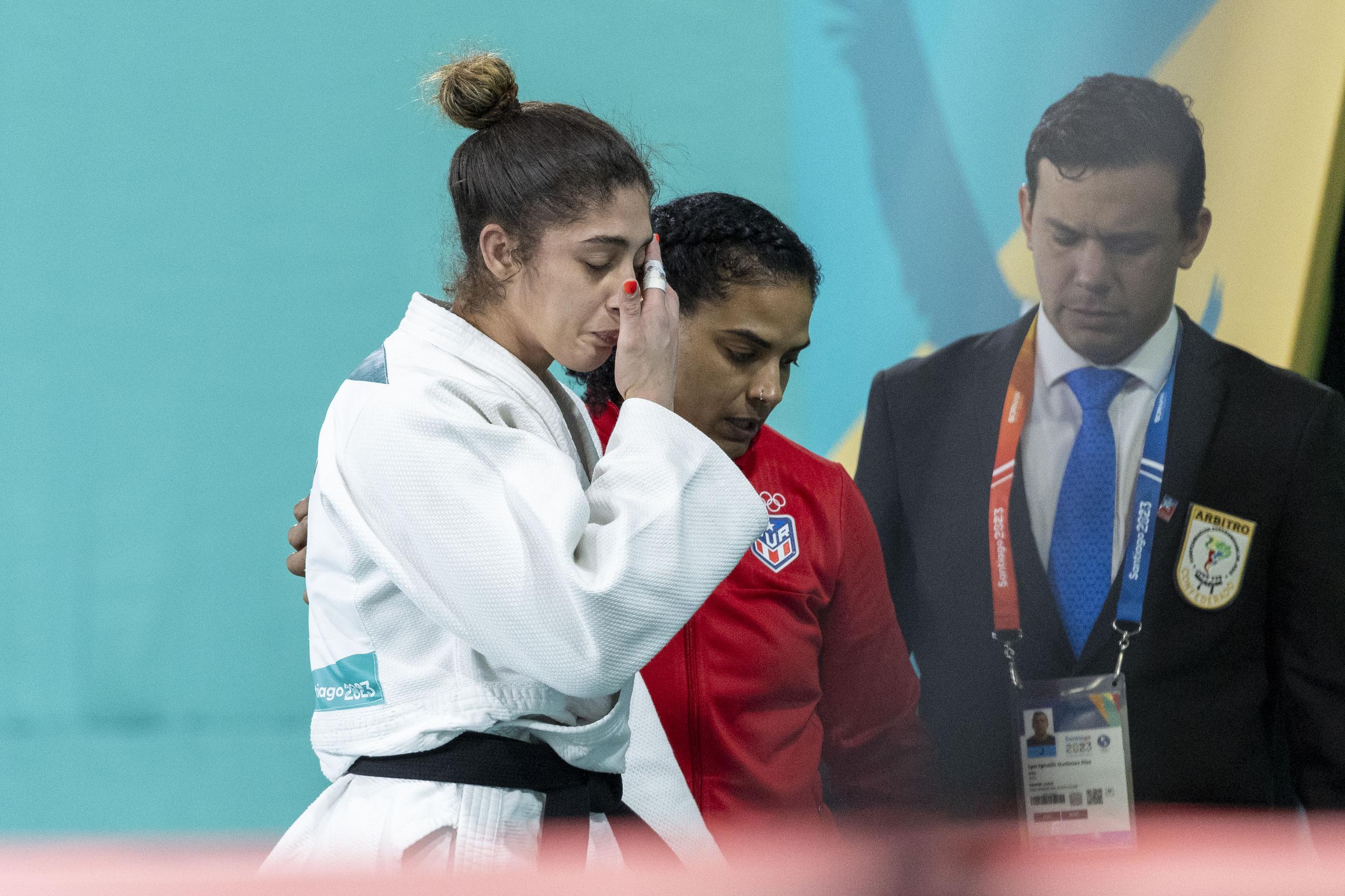 Jessica García, con uniforme rojo, aparece aquí consolando a Sairy Colón al terminar su combate esta tarde, en el que disputó la medalla de oro pero se quedó con la plata.