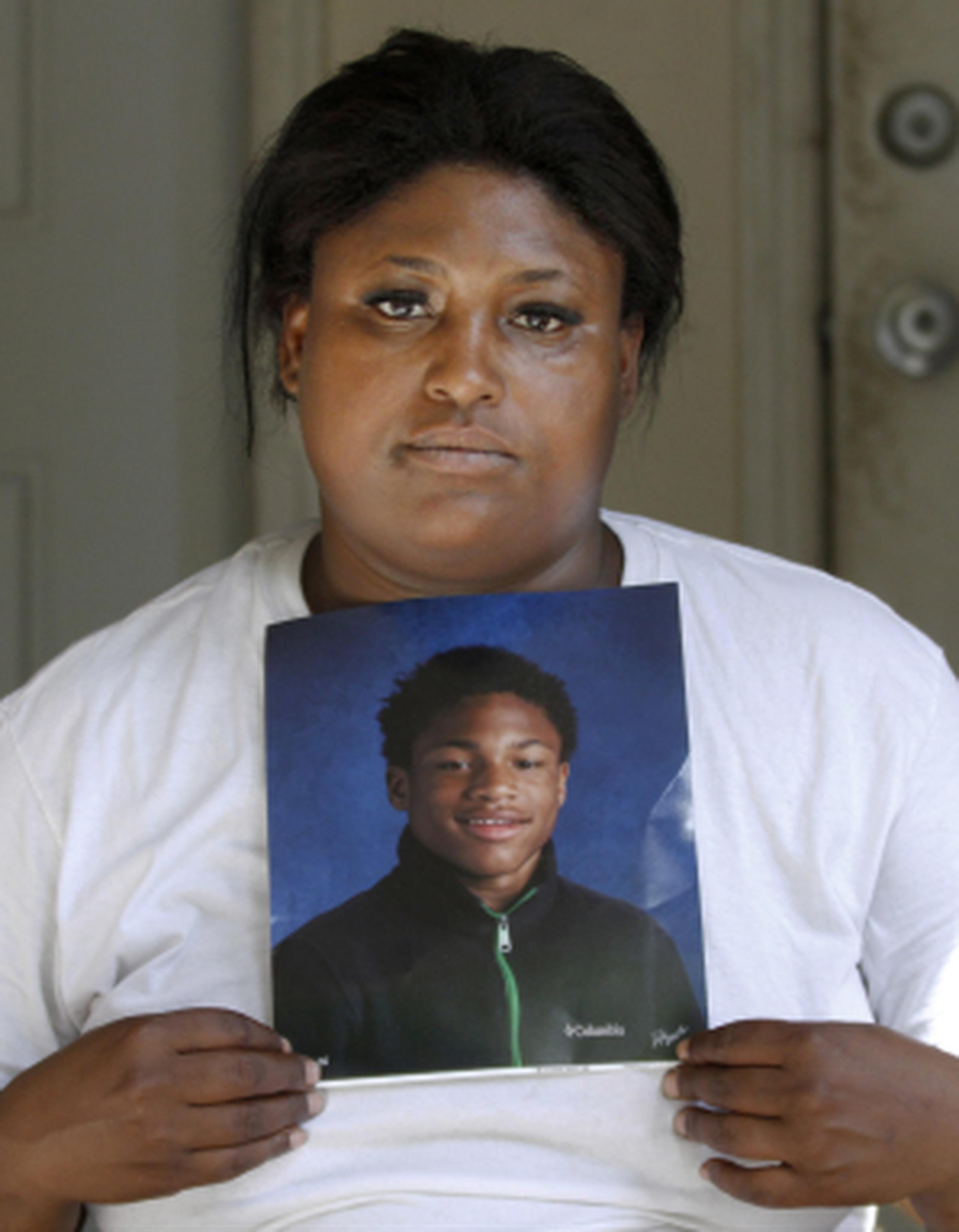 Monique Causey muestra un retrato de su hijo de 14 años, Malik Causey, quien murió baleado a solo unas cuadras de su casa. (AP/Tae-Gyun Kim)
