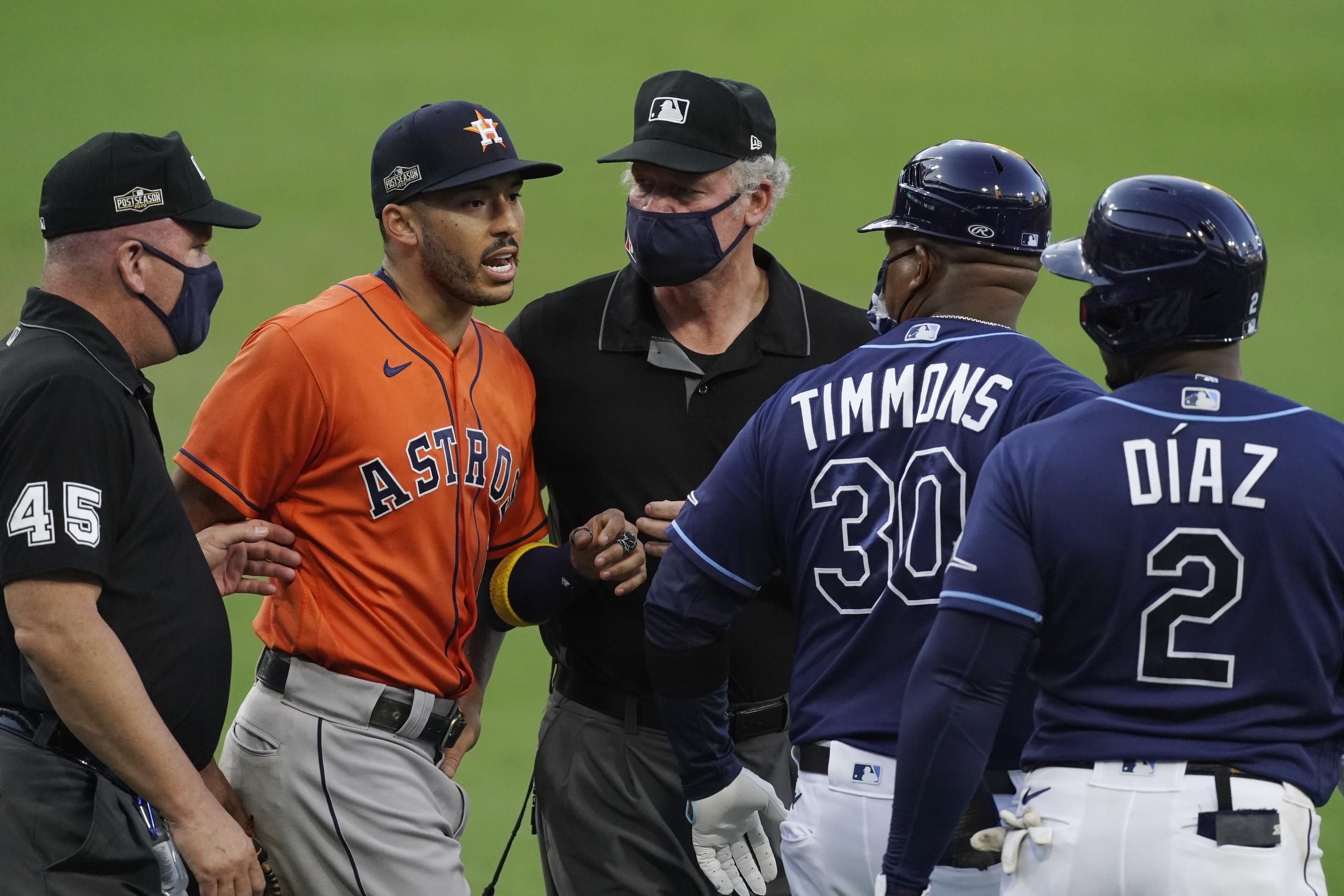 Carlos Correa intercambia palabras con el coach de primera base de los Rays Ozzie Timmons y el tercera base Yandy Díaz durante la sexta entrada.