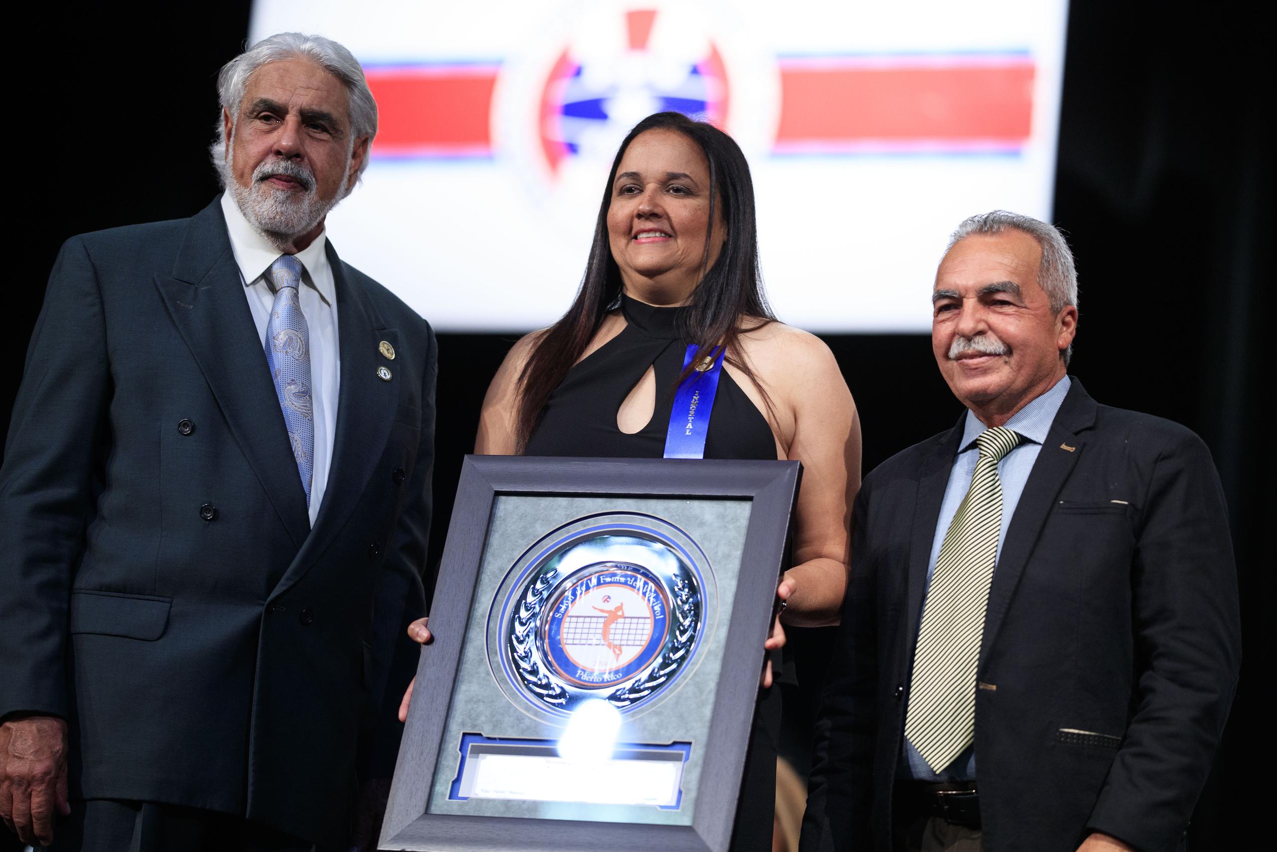 Xiomara Molero posa junto a la placa que recibió para confirmar su exaltación el Salón de la Fama del Voleibol de Puerto Rico.