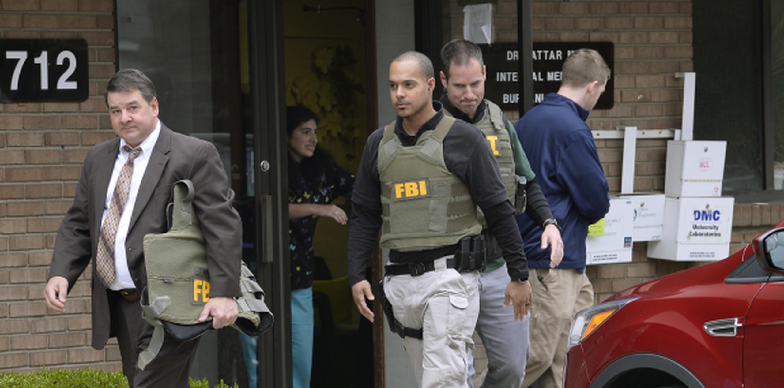 Agentes del FBI saliendo de la oficina del doctor Fakhruddin Attar en la Clínica Burhani en Livonia, Michigan. (AP / Clarence Tabb Jr. / Detroit News)