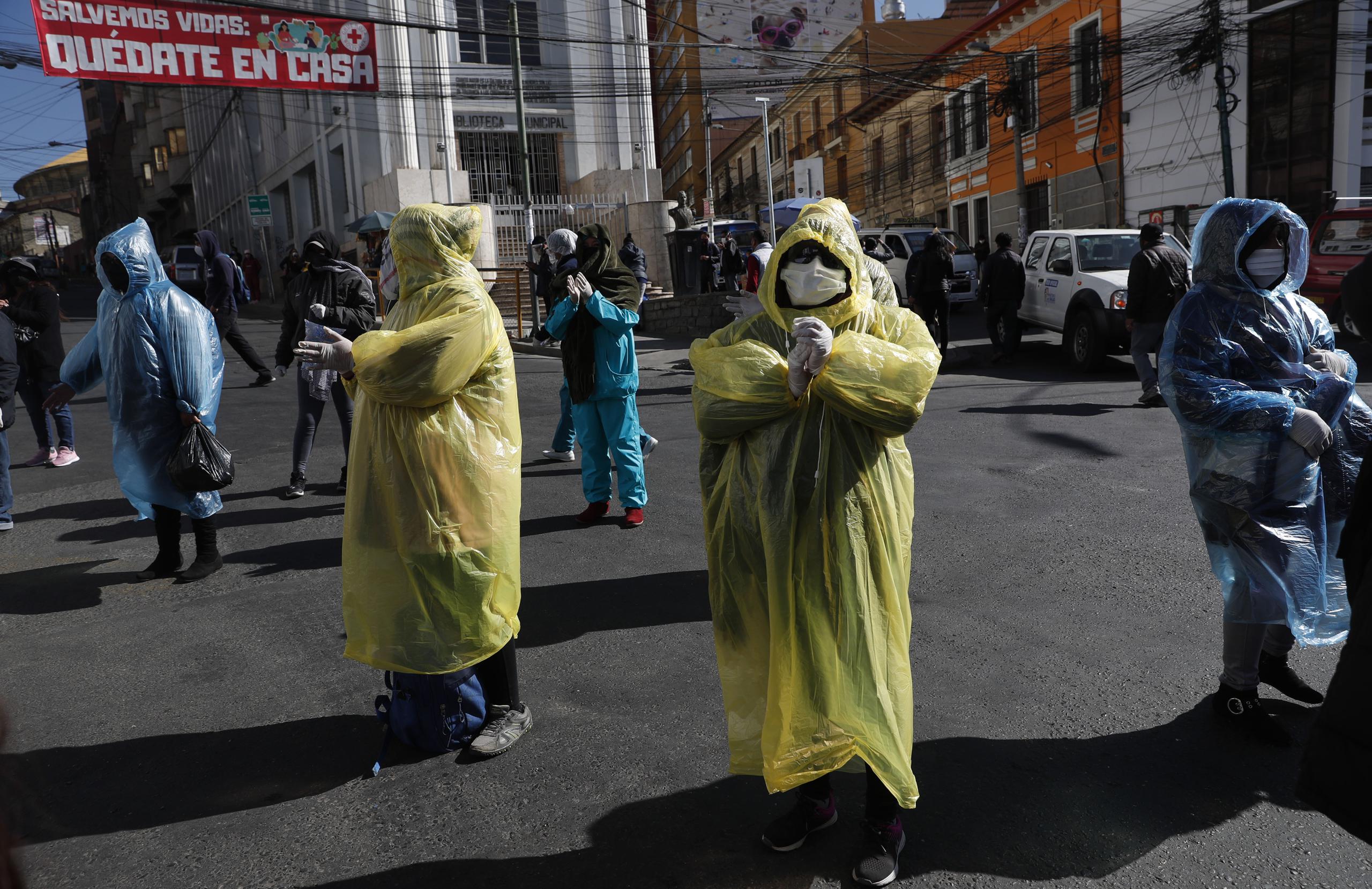 Trabajadoras sexuales con impermeables y mascarillas en medio de la pandemia del nuevo coronavirus protestan en demanda de que el gobierno levante restricciones que les impiden trabajar en La Paz, Bolivia