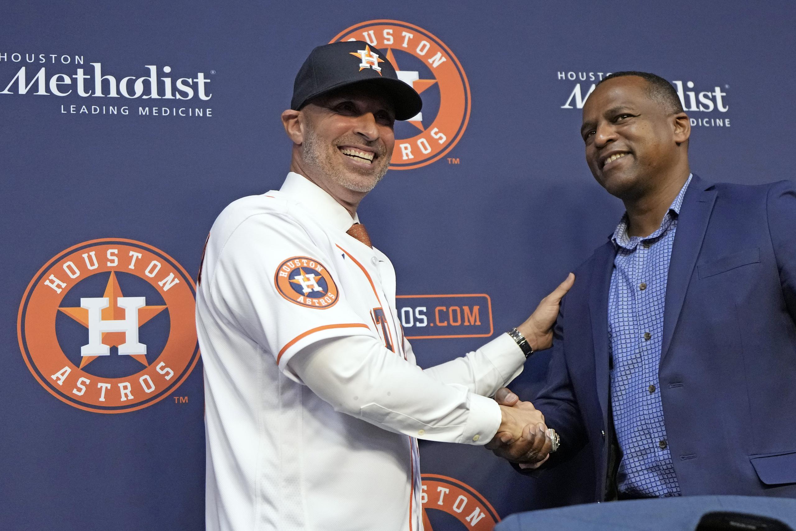 El nuevo mánager de los Astros de Houston, el puertorriqueño Josué Espada le da la mano al gerente general, Dana Brown, en conferencia de prensa.