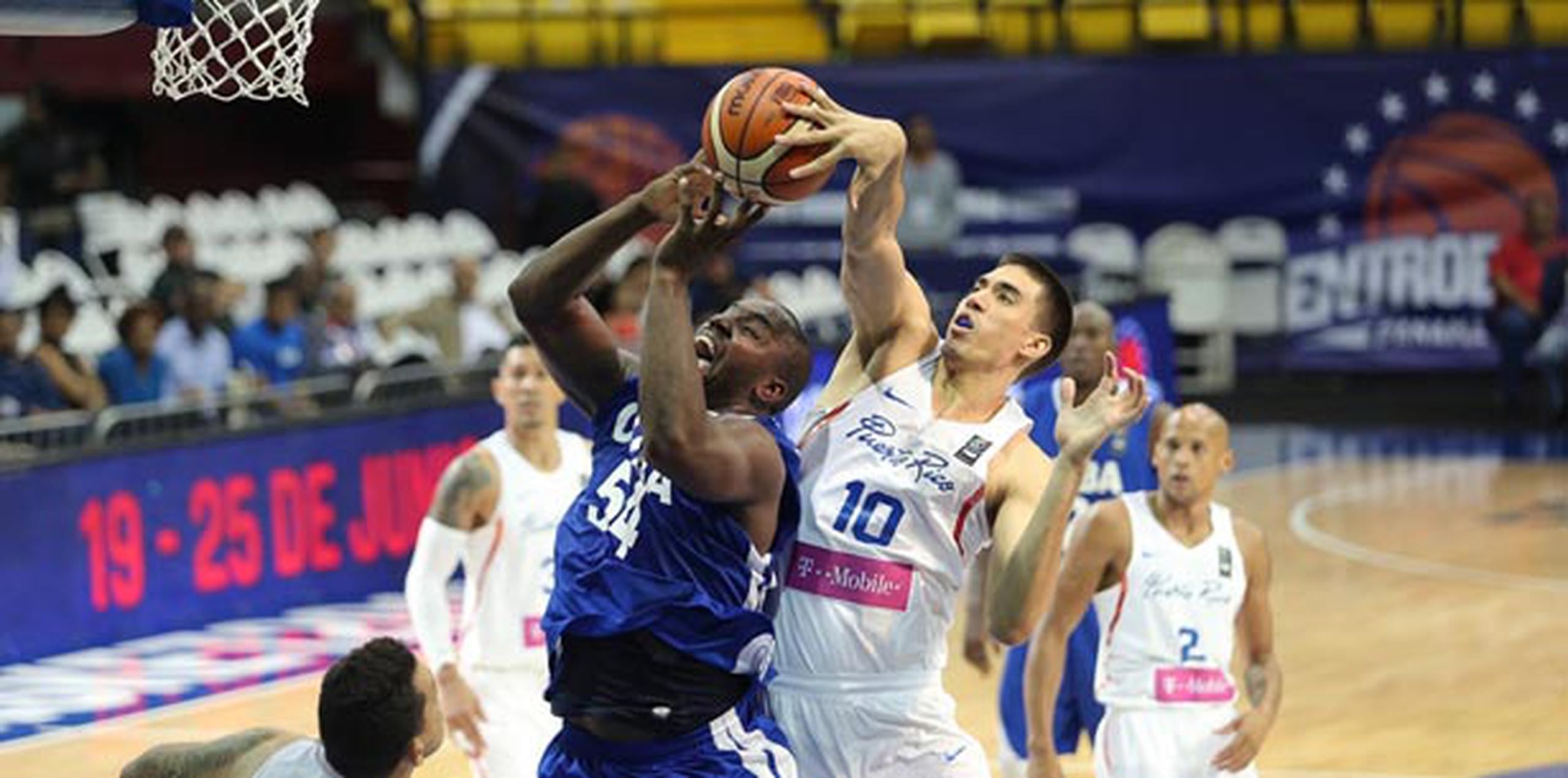 El centro de Puerto Rico, Jorge Bryan Díaz, le pone un tapón a su contraparte cubana, Yoan Luis, durante el juego de anoche. (Suministrada / FIBA Americas)