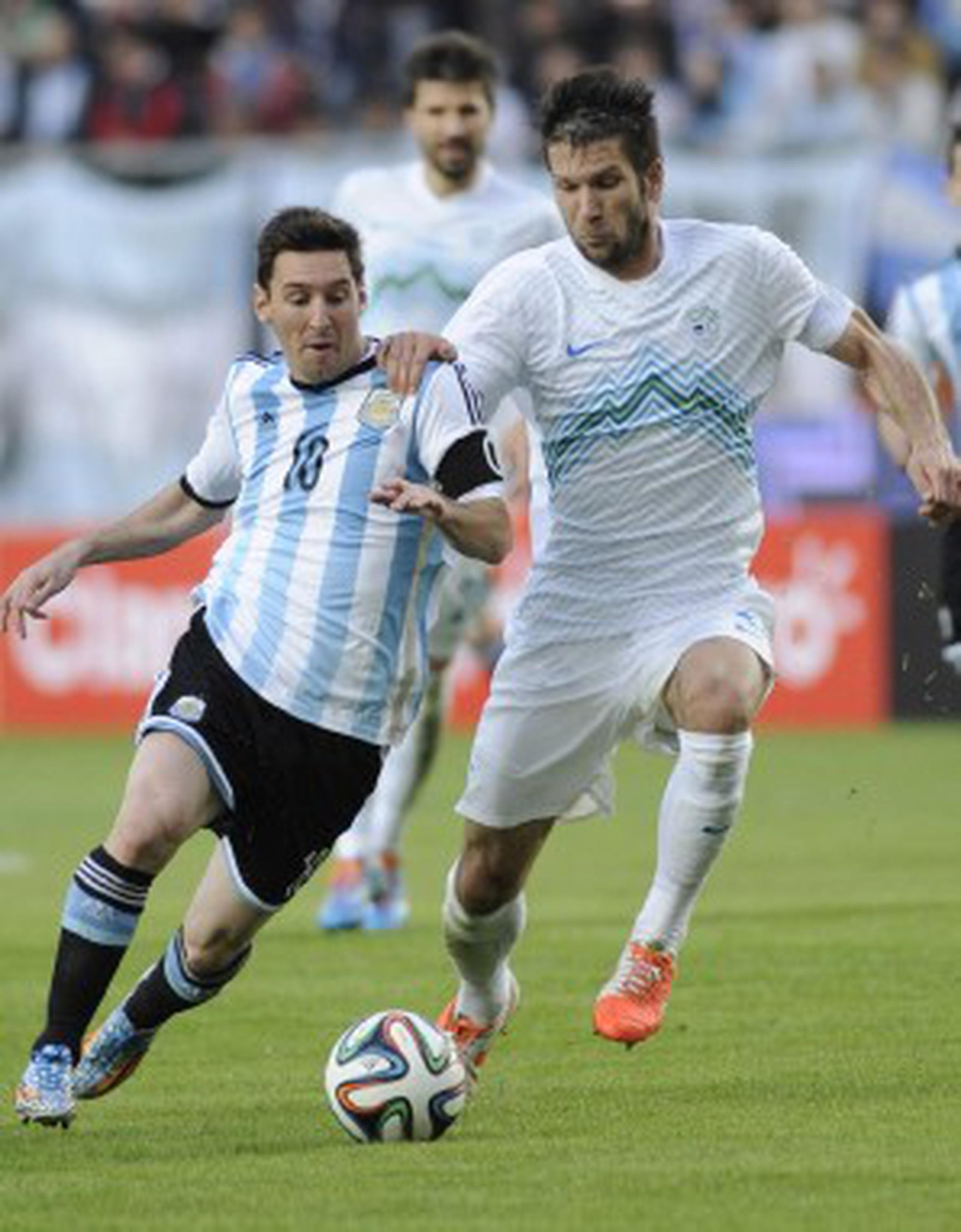 Lionel Messi, de Argentina, lucha por el balón con Miral Samardzic, de Eslovenia, durante su partido de fogueo del sábado. (EFE / Demián Estevez)