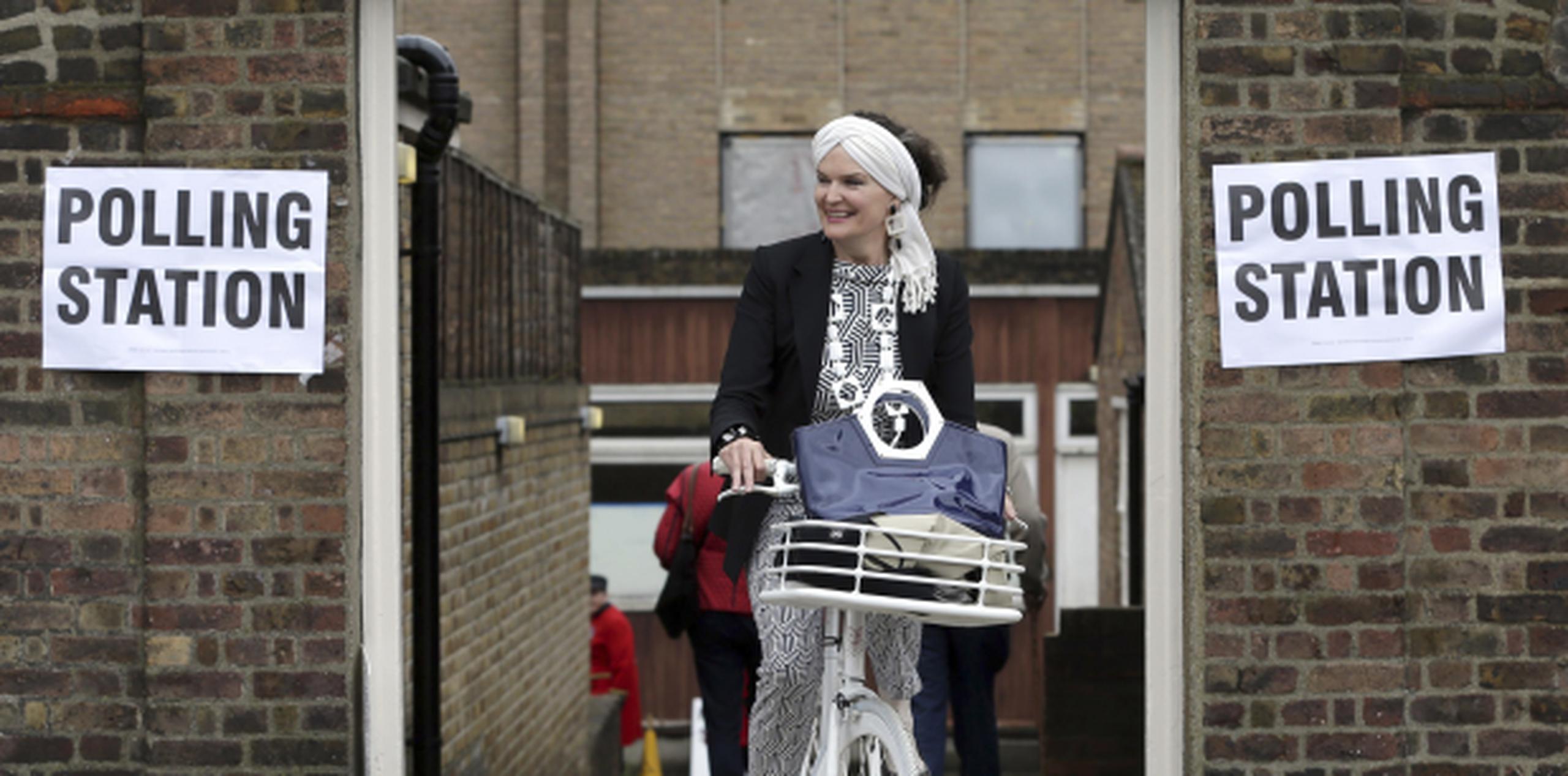 Una londinense en bicicleta acude a votar. (AP)