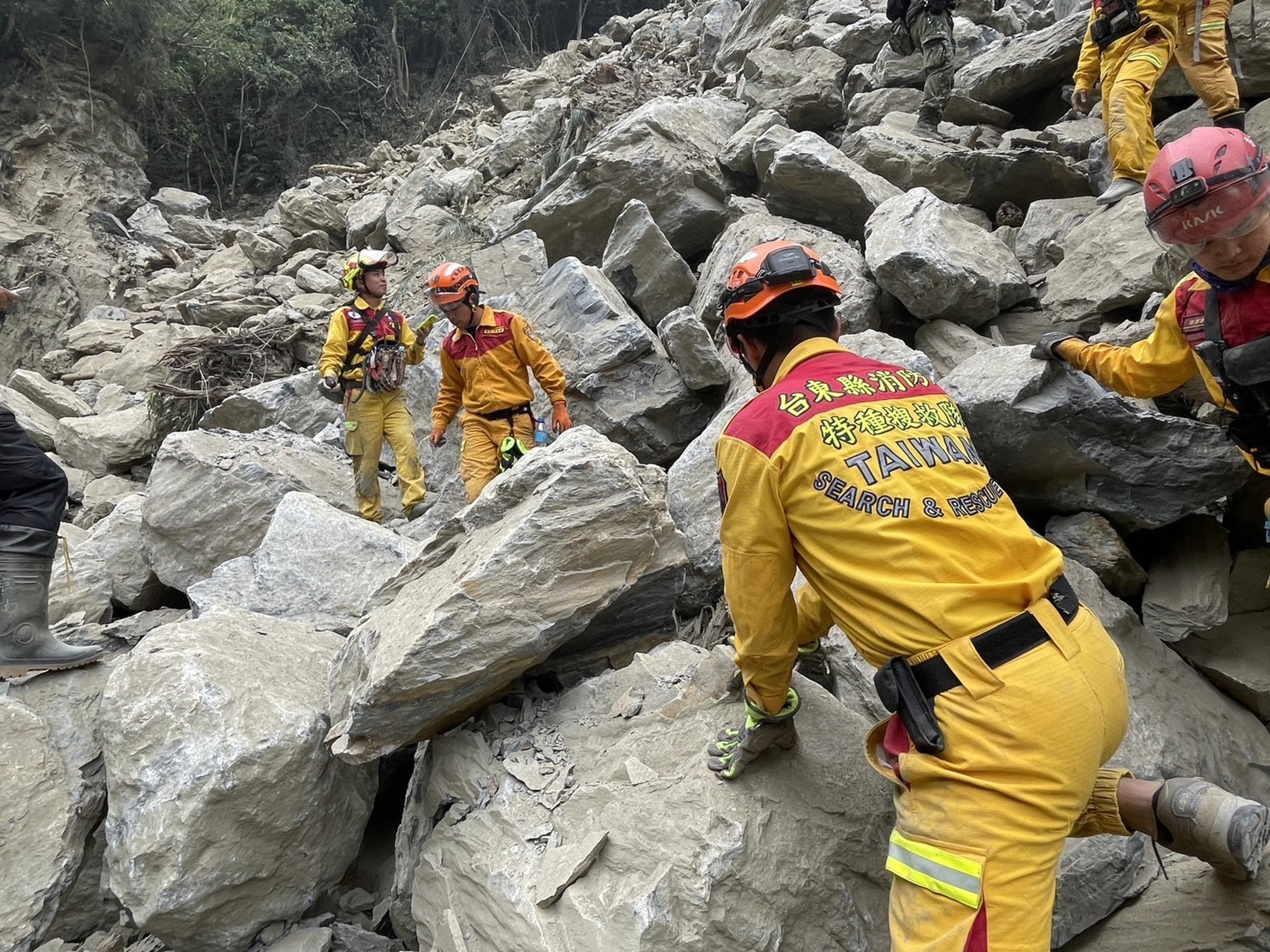 Rescatistas trabajando para recuperar el cuerpo de una mujer bajo rocas caídas en Hualien.