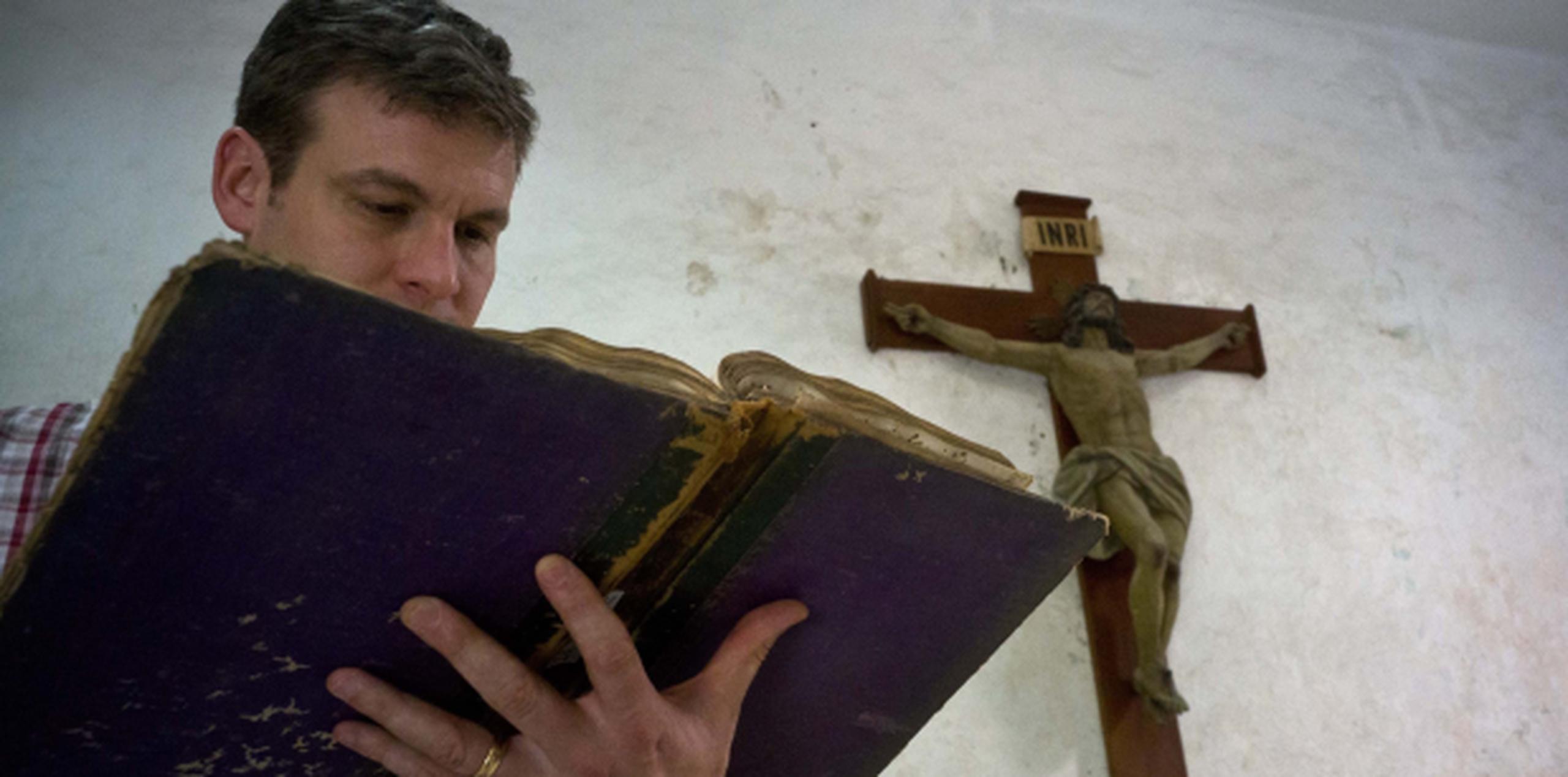 El profesor David Lafevor inspecciona un libro de esclavos en la Iglesia Espíritu Santo en La Habana. (AP)
