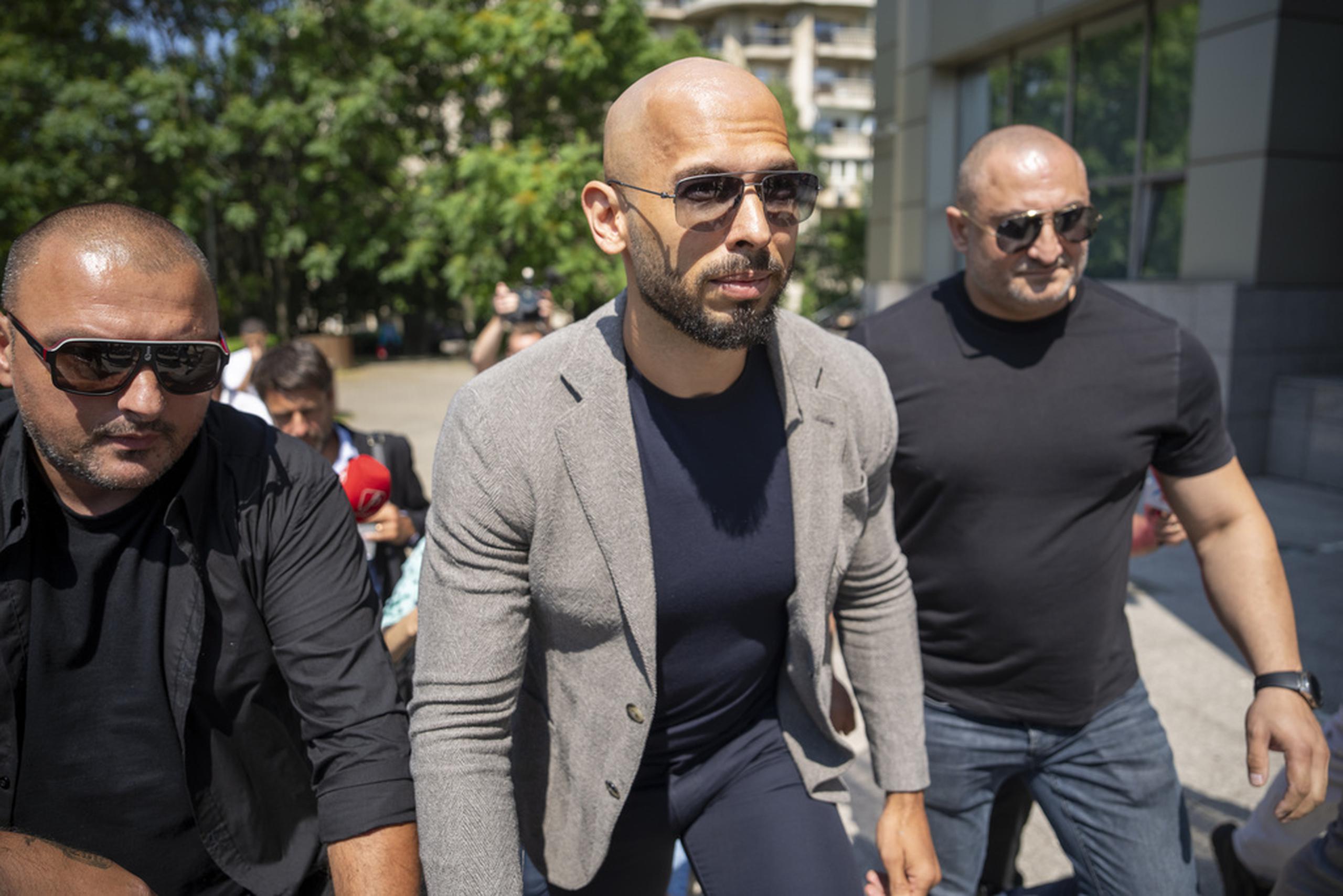 Andrew Tate camina entre guardaespaldas en su llegada a un tribunal en Bucarest, en Rumanía, este miércoles.