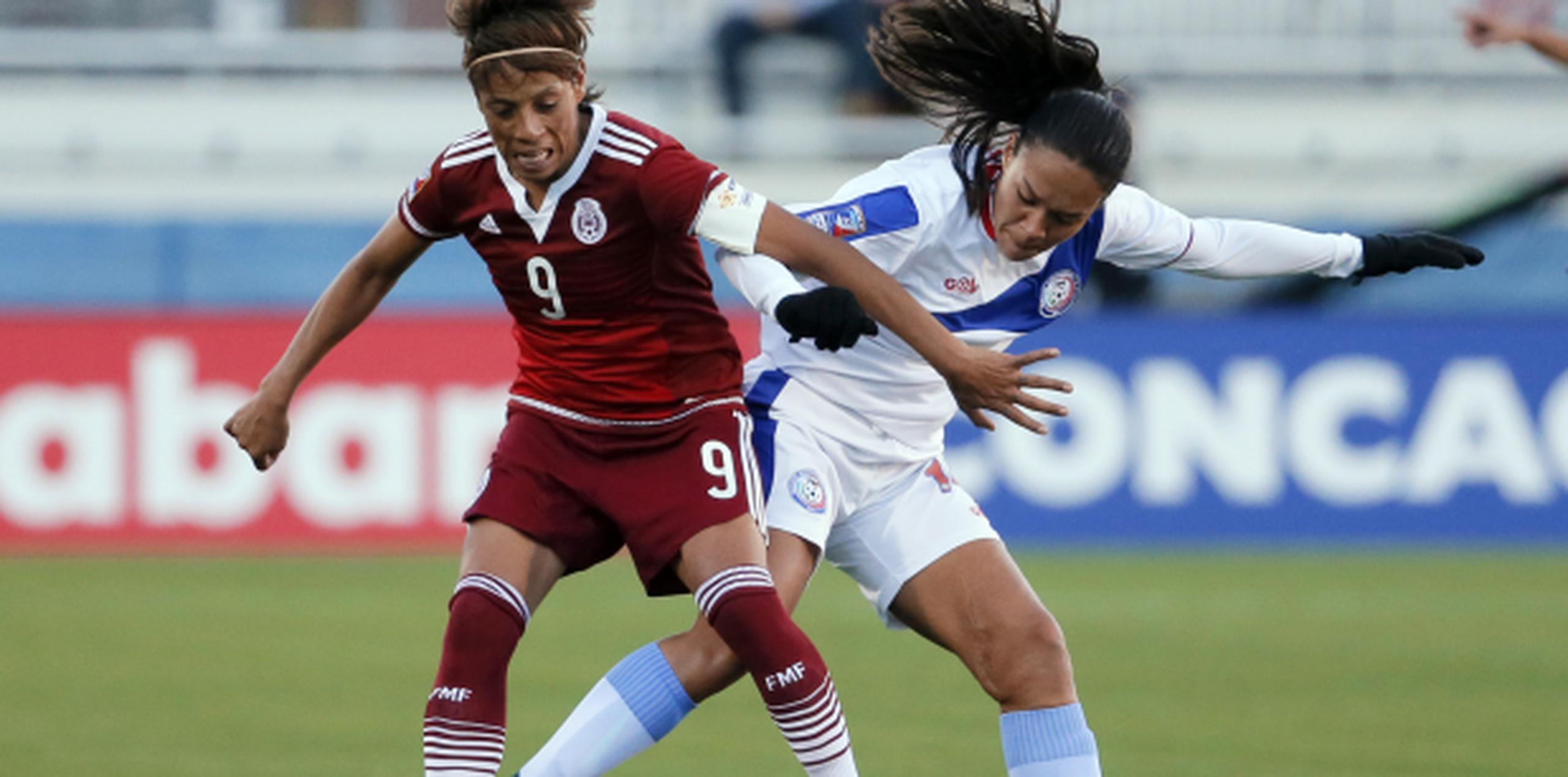 La mexicana Maribel Domínguez protege el balón ante la boricua Ashley Rivera. Domínguez consiguió un triplete en la victoria de México por 6-0. (AP/Tony Gutierrez)
