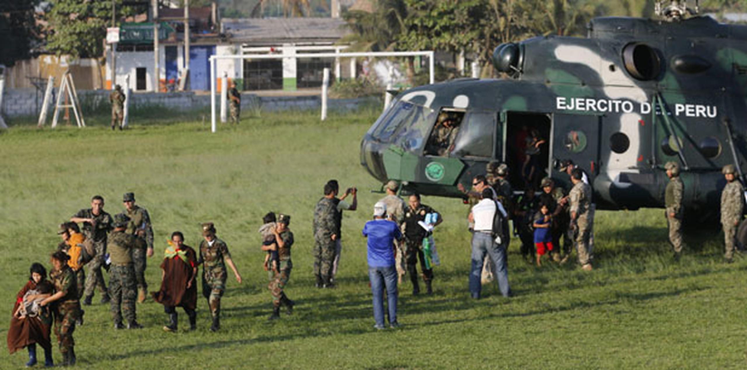 Varias personas rescatadas por el Ejército que descienden de un helicóptero tras su rescate, en Junín (Perú).  (EFE / Prensa del Ministerio de Defensa)