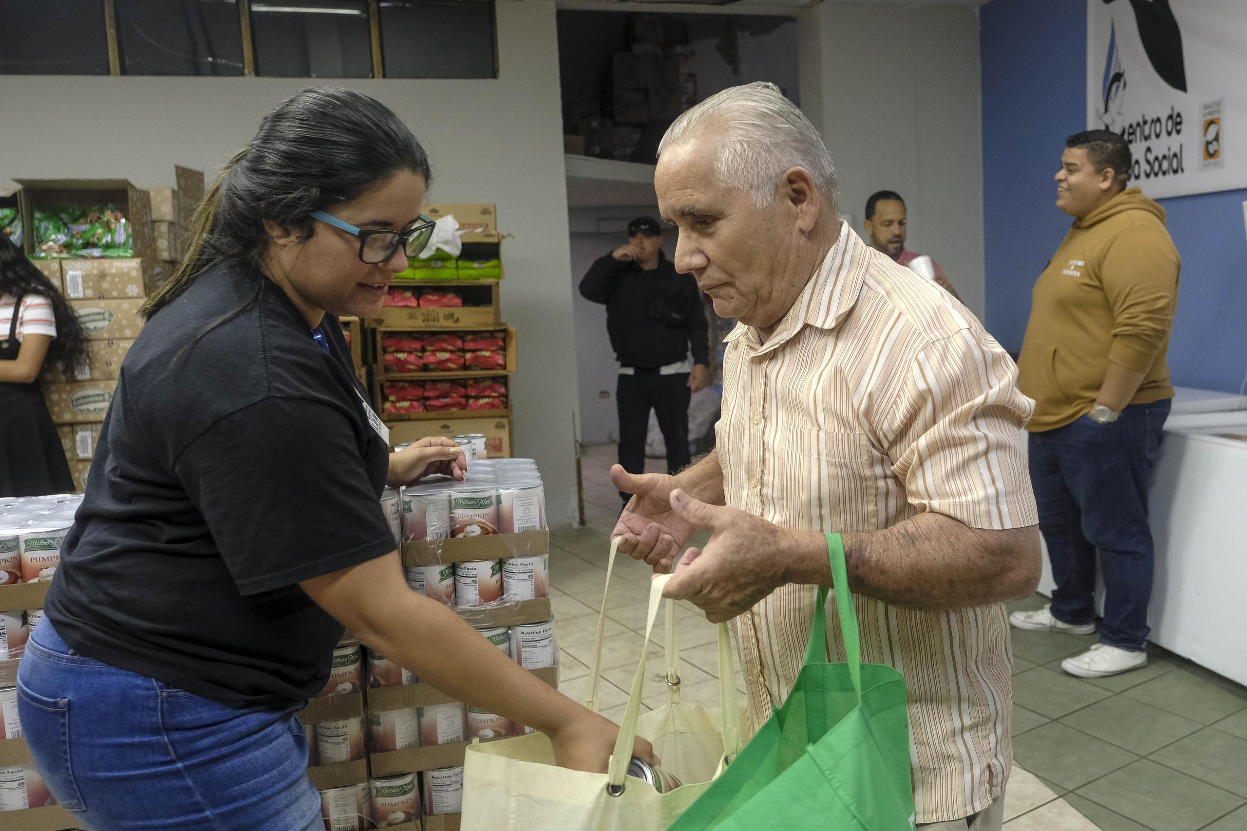 En la foto, Jeremías Rosa recibe alimentos en una especie de supermercado donde dan comida gratis a los que llegan a buscar la ayuda.