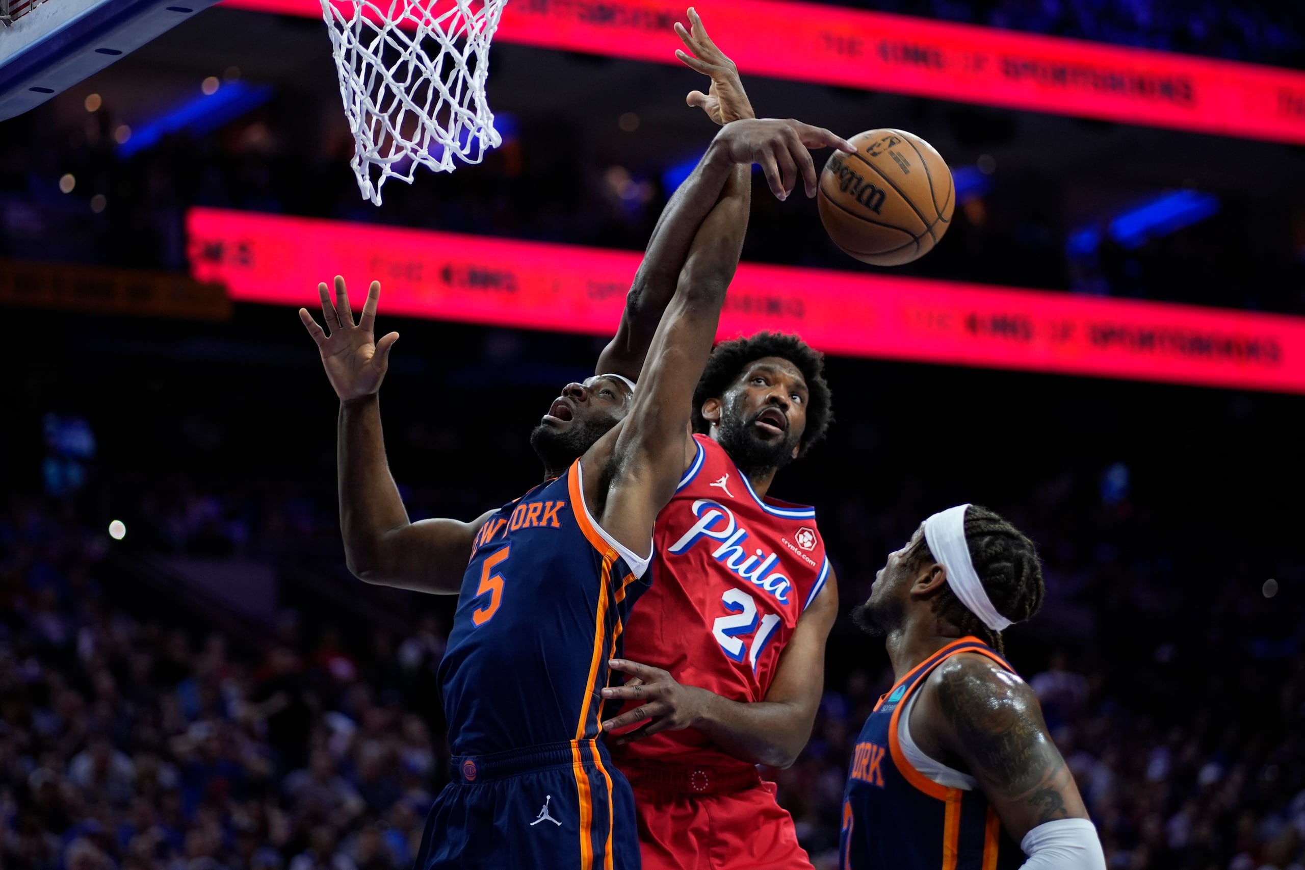 Joel Embiid se levanta, pesa a varias lesiones que está manejando, para luchar un rebote en el partido.